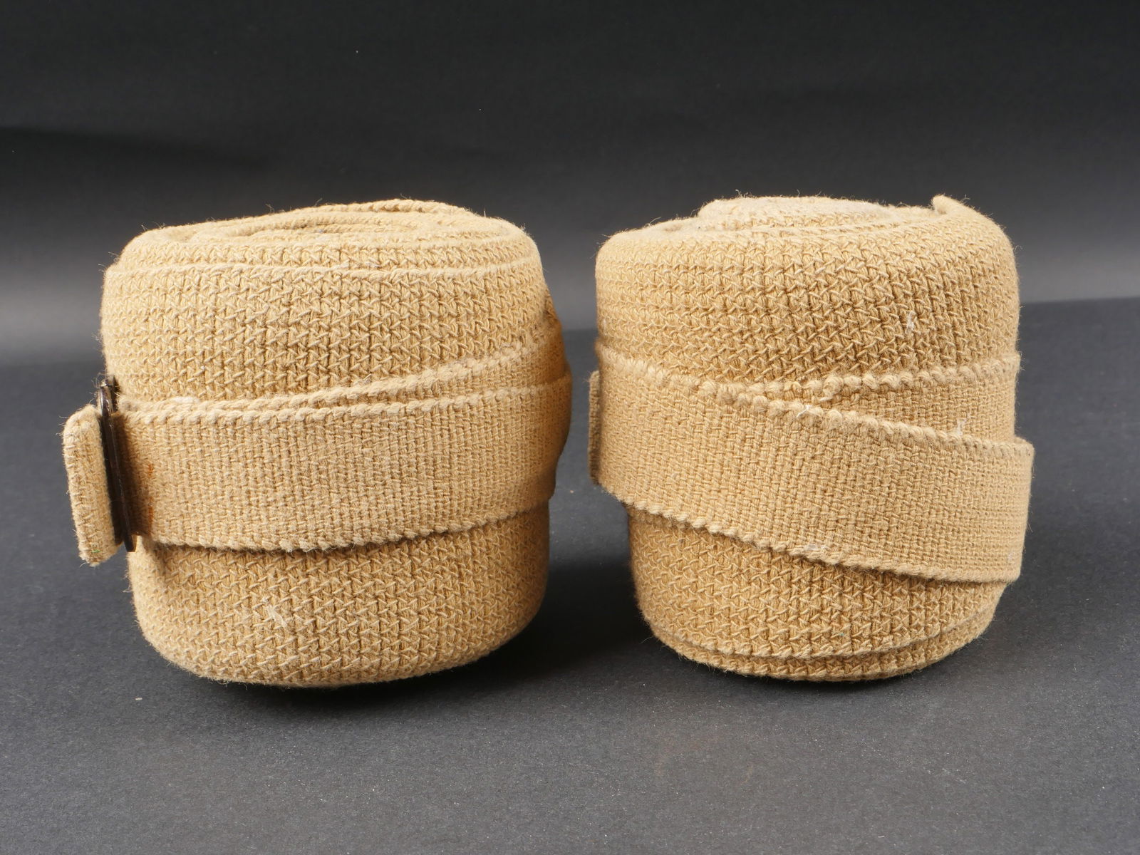 Bandes molletieres AK. German afrika gaiters.: Bandes molletieres tropicales. Paire homogene en forte toile beige. Les sangles de serrage sont presentes. Sans marquages visibles. A noter une certaine usure et patine des pieces. Etat II+. Tropical