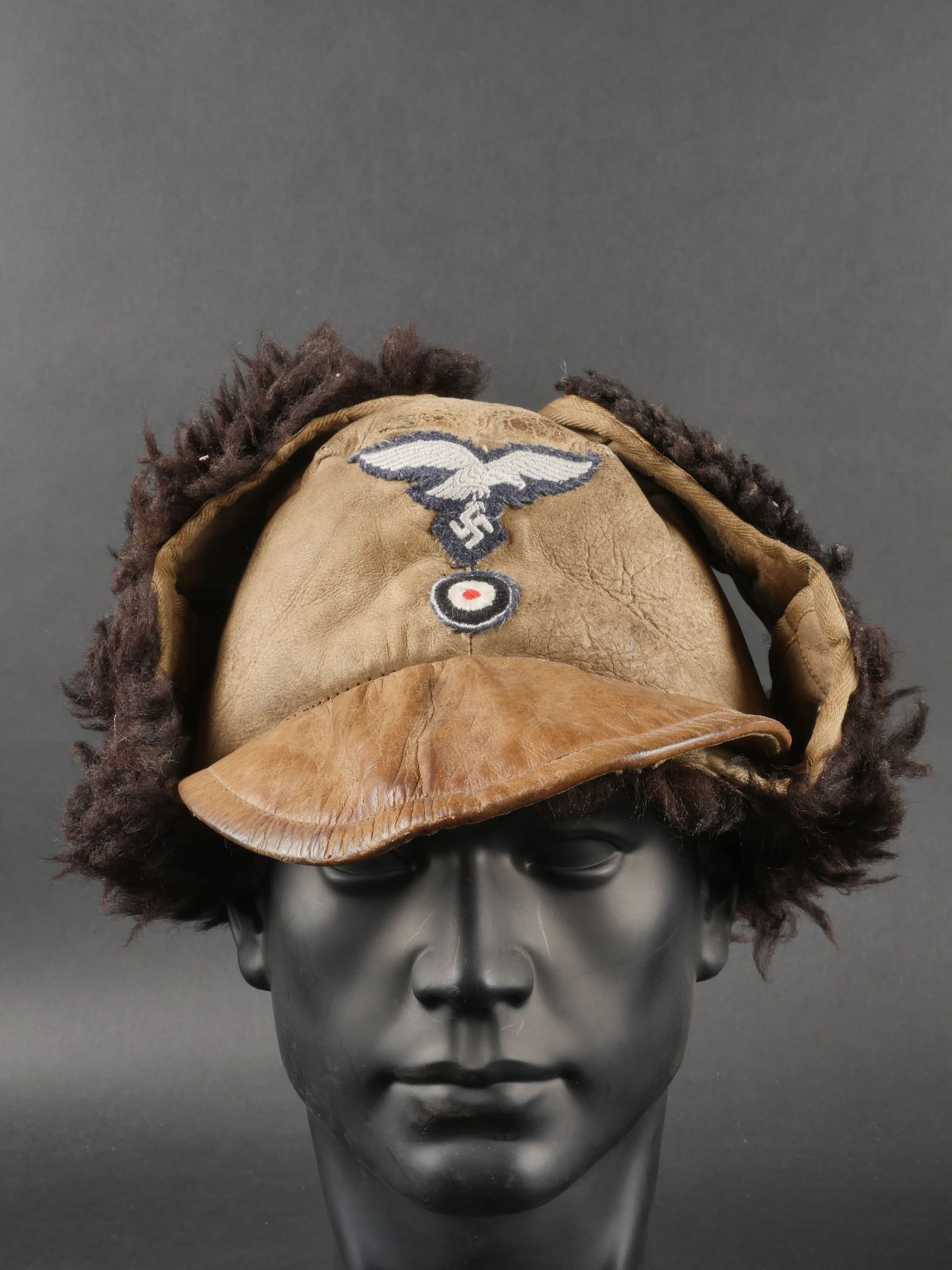 Bonnet hivernal LW. Luftwaffe winter cap.: Bonnet hivernal de la Luftwaffe. En cuir retourne beige. Doublure en fausse fourrure marron. Les sangles de maintien des rabats sont presentes. Visiere double d un tissu Feldgrau. Aigle et cocarde cou