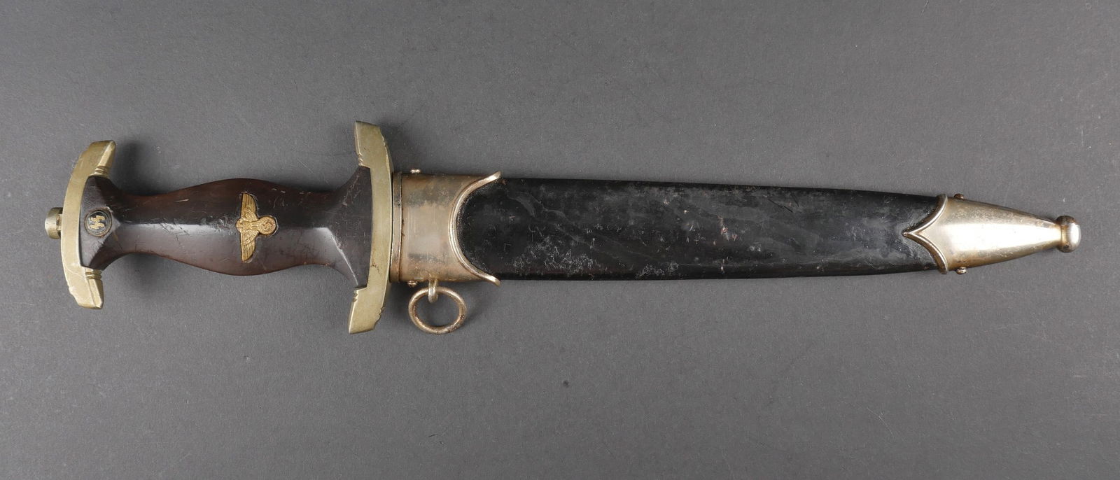 Dague SS. German SS dagger.: Dague SS. Modele 33. Garnitures en metal. Poignee en bois. Insigne SS visiblement monte d origine. Aigle allemand visiblement remonte. Ensemble homogene. Belle lame presentant de traces d oxydation. D