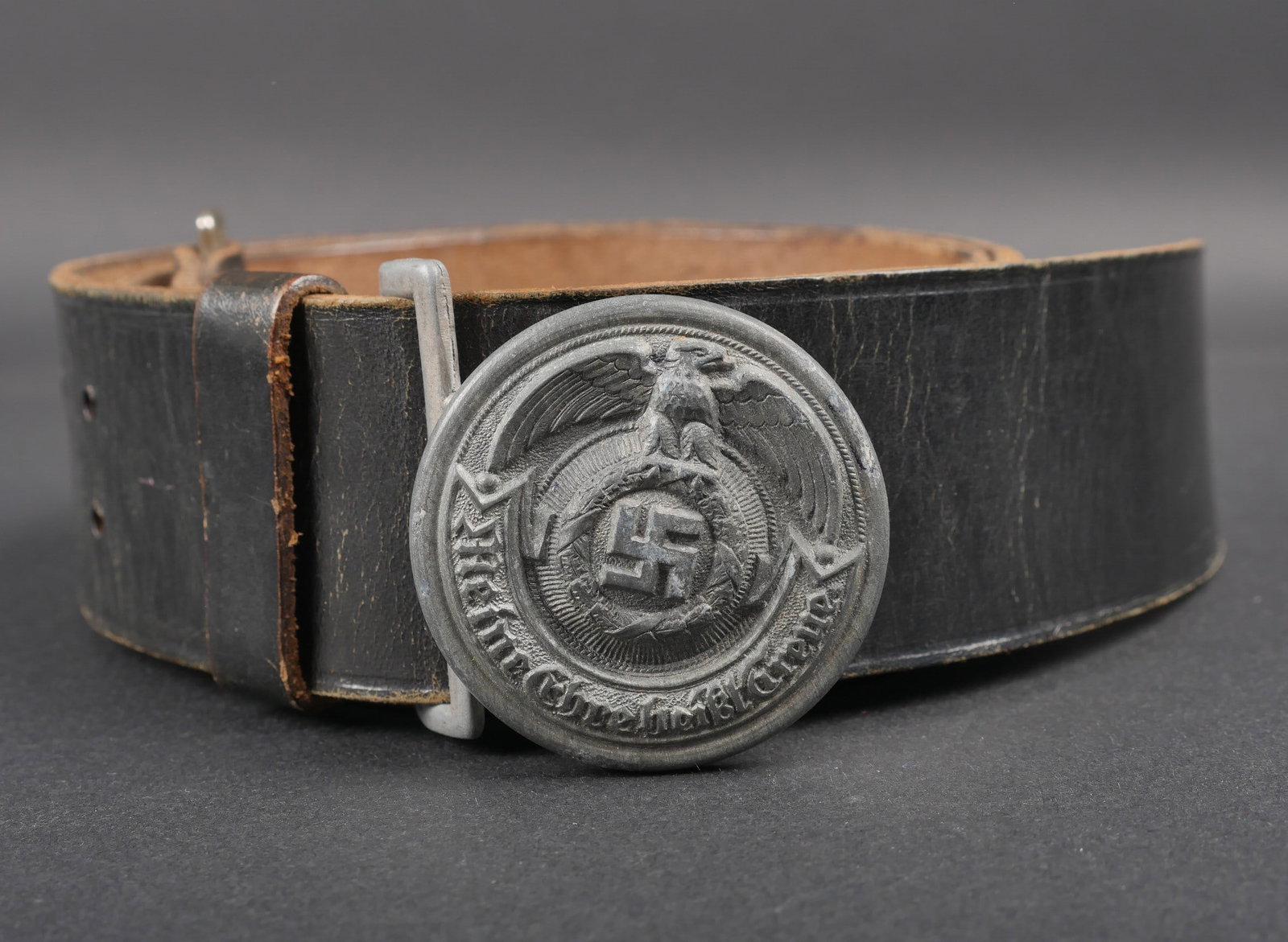 Ceinturon d officier SS. SS Officer s Belt.: Ceinturon d officier SS. Ceinturon en cuir noir. Bouclerie en metal. Marquages Groupon. Un passant de ceinturon present. Boucle en metal, logo du fabricant present. Boucle a deux ardillons presente. A