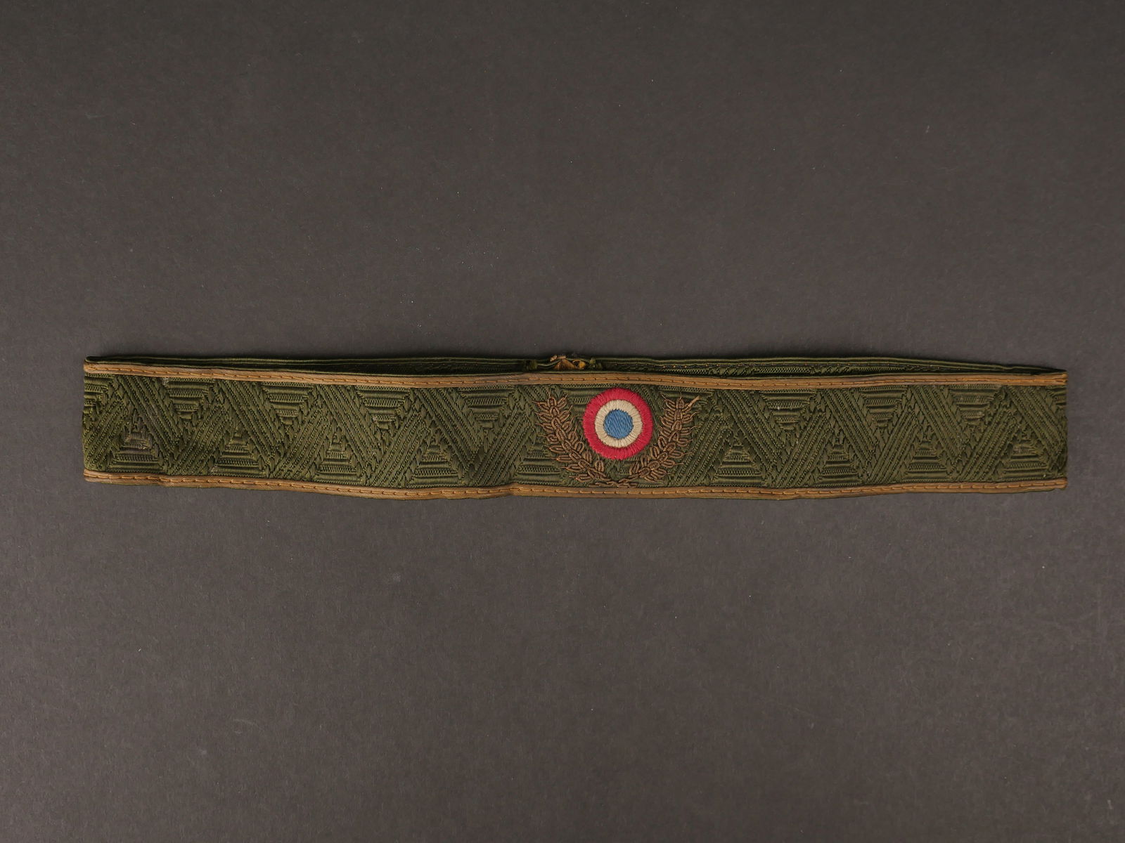 Bandeau du RAD Hollandais. Band of the Dutch RAD.: Bandeau du RAD Hollandais. En tissu kaki, cocarde rouge/blanche/bleu brodee. Feuilles de chene en cannetille or. Double lisere en tissu or. Le dos de l insigne est renforce en epais papier. Visiblemen