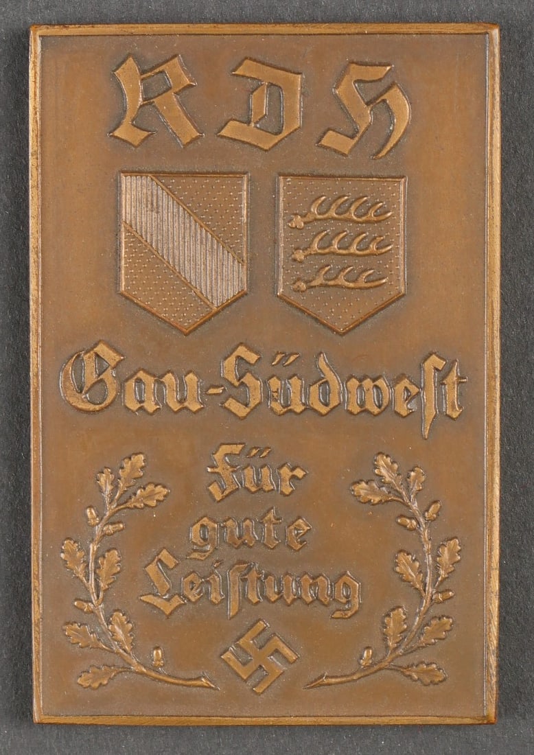 Plaquette RDH. RDH plaque.: Plaquette RDH. En metal. Marquages RDH Gau Sudwest fur gute Leistung. Traces de colle au dos. Dimensions 4 x 6 cm. A noter une certaine usure et patine de la piece. Etat II+. RDH plaque. Made of metal