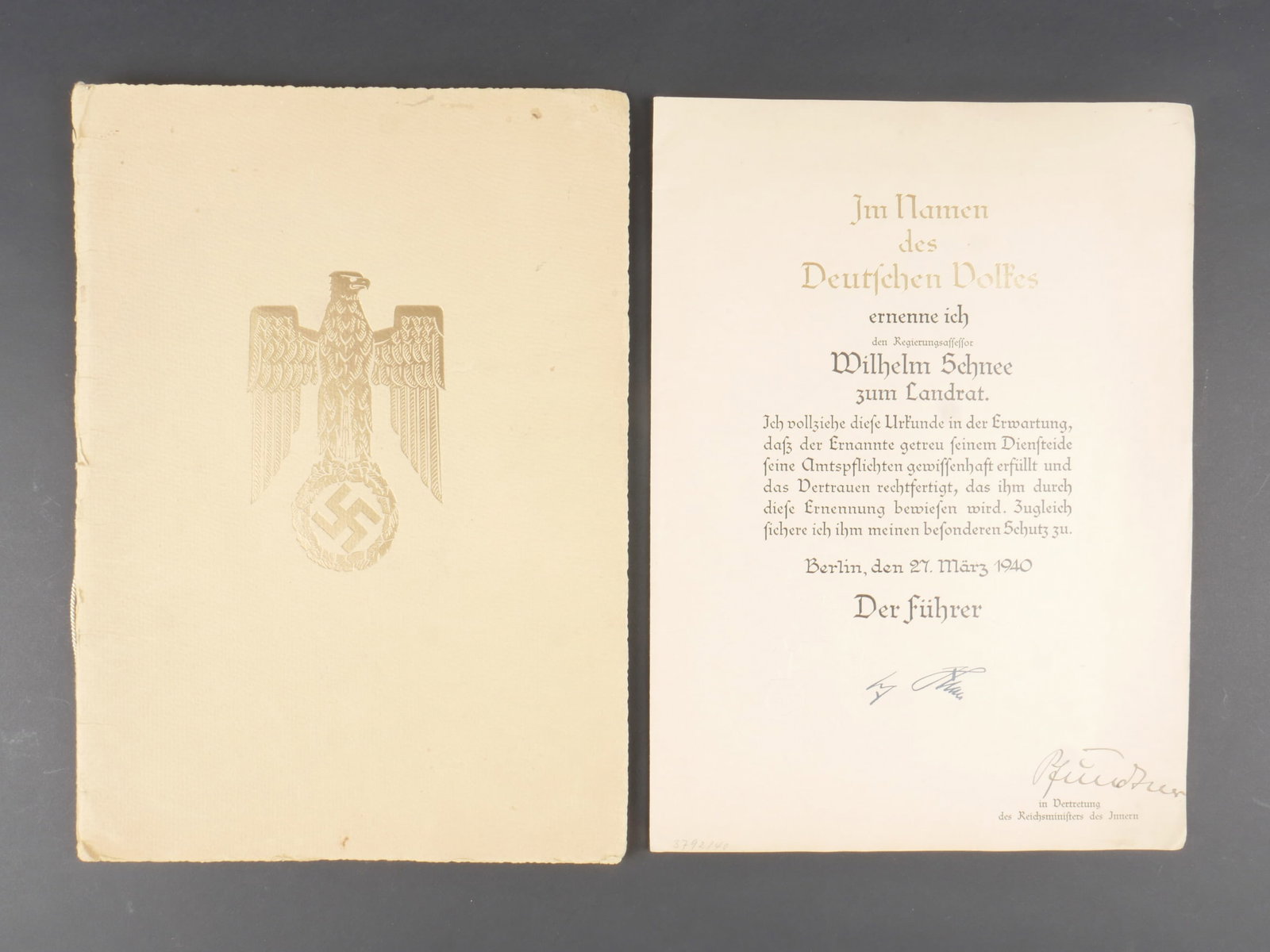 Diplome allemand. German diplomas.: Diplome allemand. Grande chemise cartonnee, disposant d un aigle dore. Contenant un diplome de promotion au poste de Chef de l administration d un district. Attribue a Wilhelm Schnee. Signatures impri