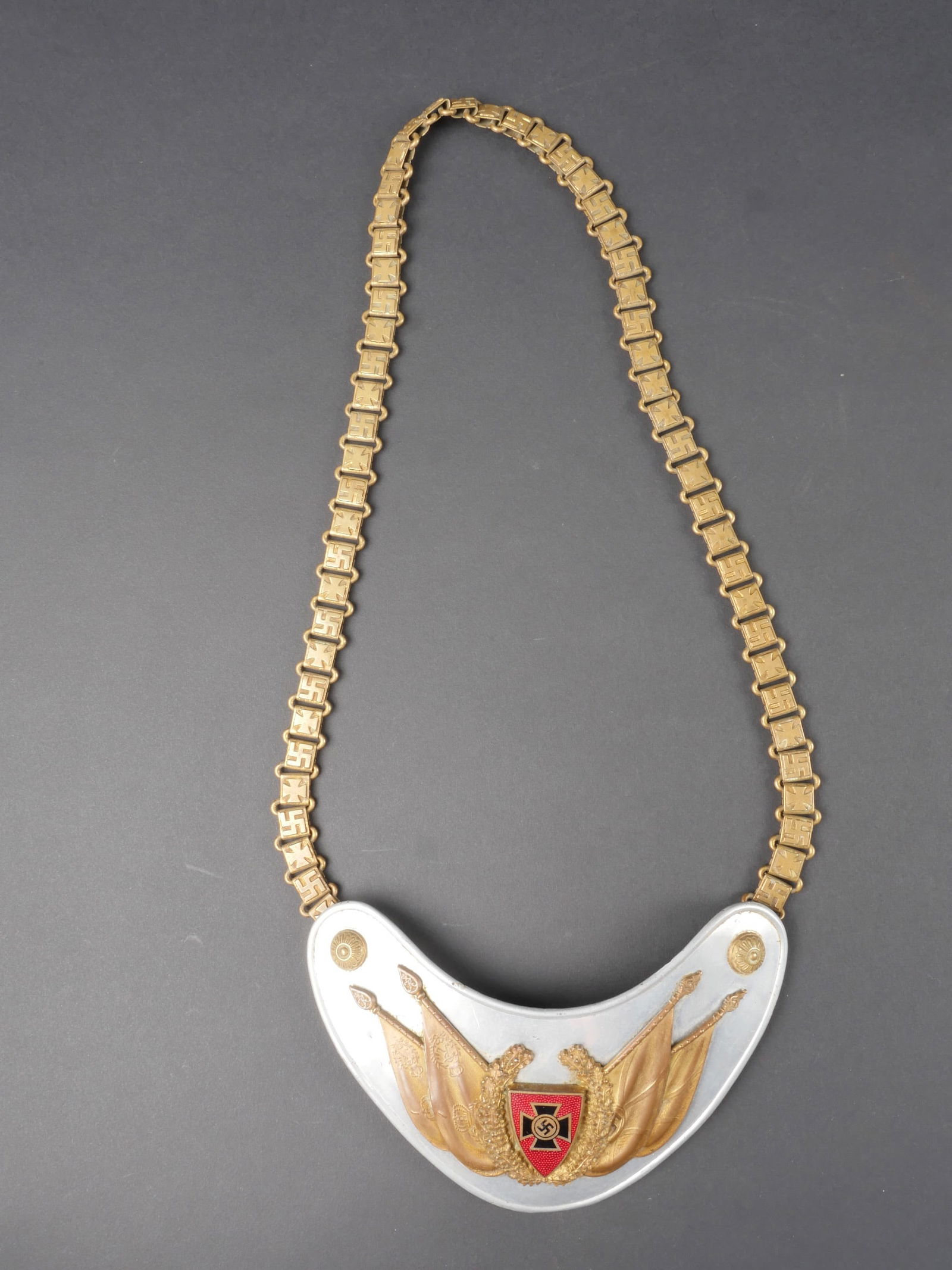 Hausse col des anciens combattants. Veteran s gorget.: Hausse col des anciens combattant. En aluminium. Insigne des anciens combattant rapporte. Les deux boutons sont presents. Chainette disposant d une alternance d insignes nationaux et de croix de fer.