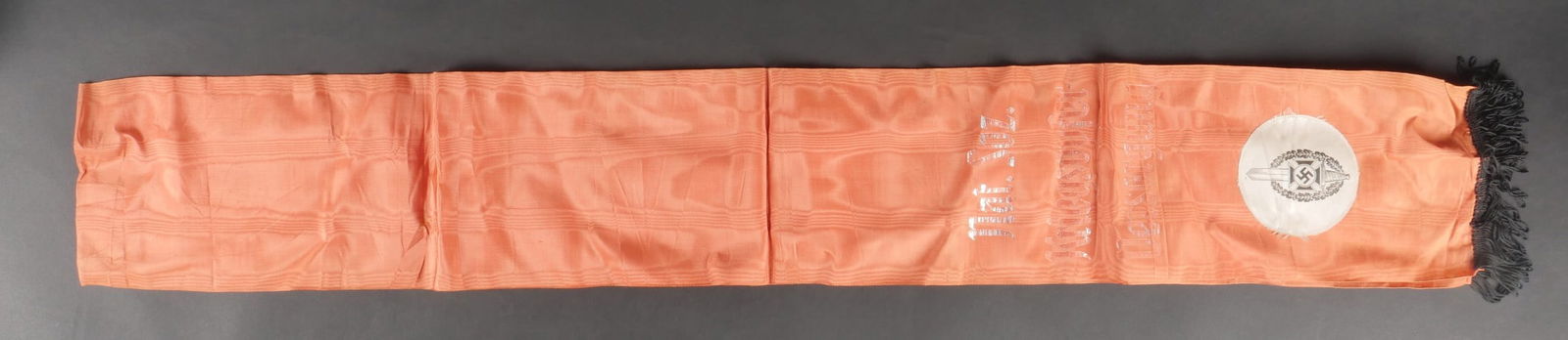 Banderole funeraire. German Funeral Ribbon.: Banderole funeraire des anciens combattants. En tissu soyeux rouge. La couleur rouge est delavee par le soleil. Franges noir des deux cotees. Insigne national imprime et rapporte. Marquages In Treue u