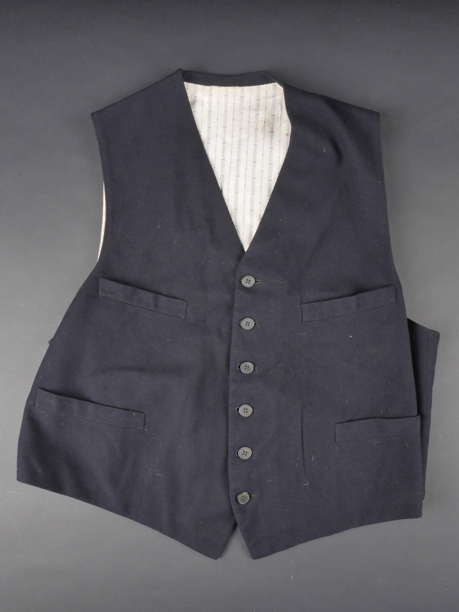Gilet d uniforme du DAF. DAF Uniform Vest.: Gilet d uniforme du DAF. En drap noir. Interieur double en tissu civil. Celui-ci dispose dans son decors de marquages DAF. Tous les boutons sont presents. Martingale complete. A noter une certaine usu