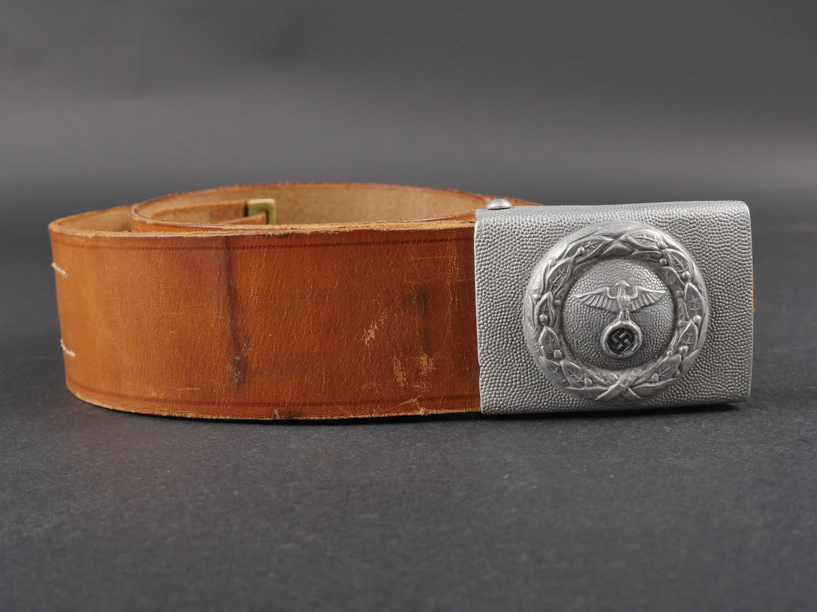 Ceinturon DLV. German DLV belt.: Ceinturon du DLV. Ceinturon en cuir marron. Bouclerie en metal. Marquages nominatif 7/112 Joe L Best. Boucle de ceinturon en aluminium grenele. Un ardillon manquant. Sans marquages visibles. A noter u