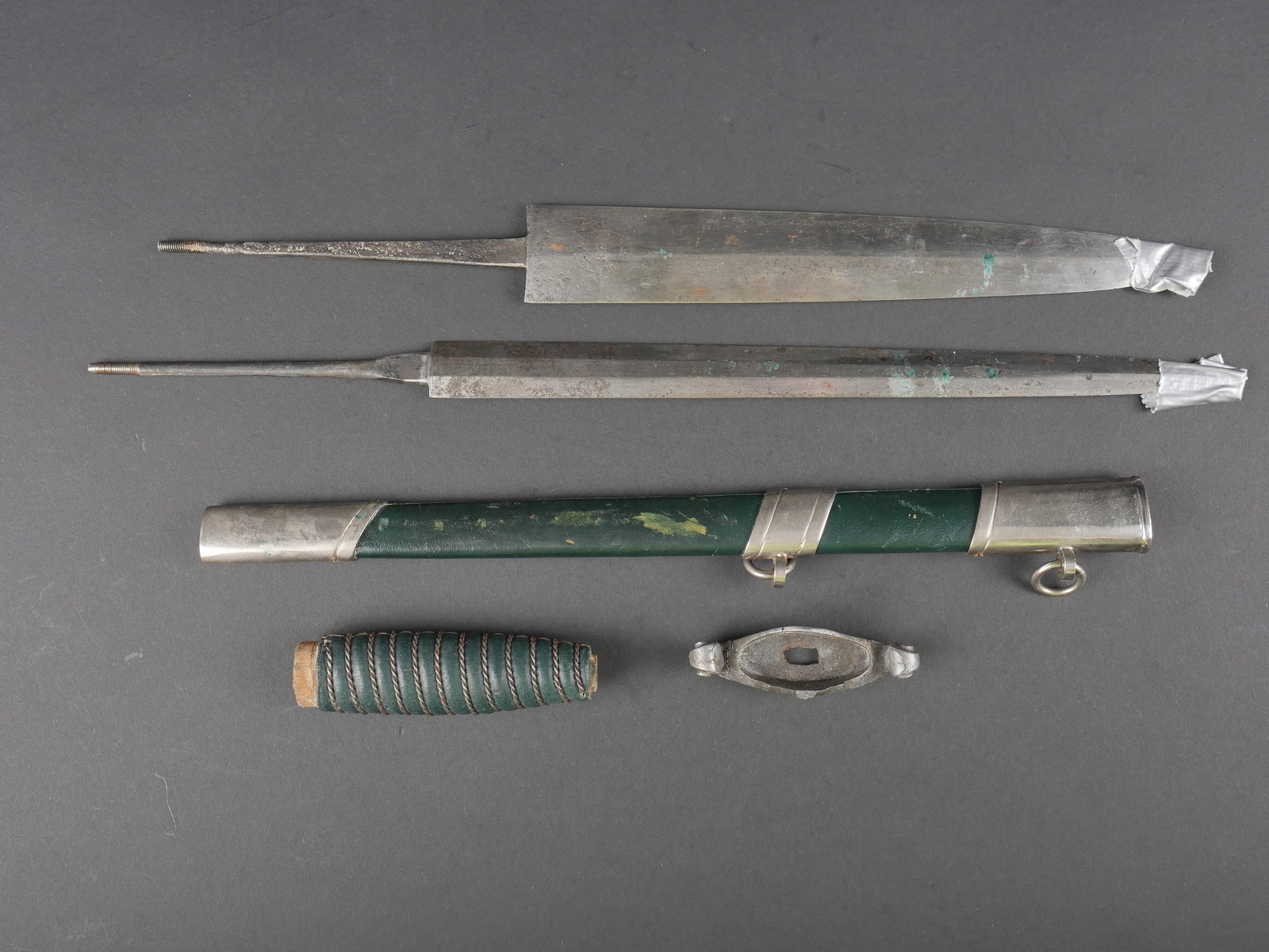 Pieces detachees pour dague douane. Spare Parts for Customs Dagger.: Pieces detachees pour dague de la douane. Comprenant un fourreau en metal leger, recouvert d un cuir vert, fortement use, avec des manques. Une lame de dague fortement oxyde avec des sillons, fabricat