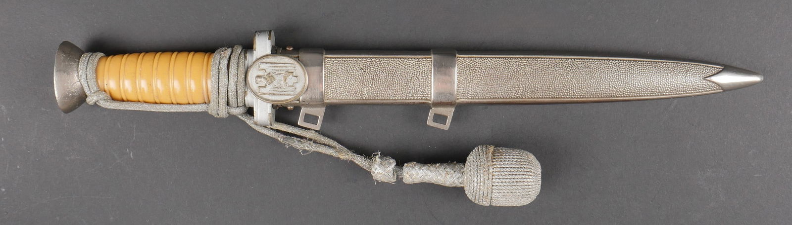 Dague officier DRK. German DRK officer dagger.: Dague d officier DRK. Les garnitures metalliques sont en bon etat. Poignee en celluloid jaune. Dragonne effilochee presente. Belle lame presentant des marquages d usures. Sans marquages visibles. Four