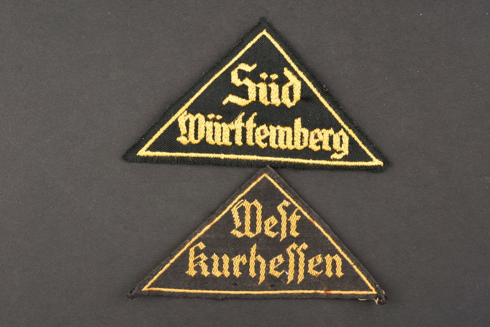 Triangles de bras HJ. Hj insignia.: Triangles de bras Hitlerjugend. Comprenant un triangle de bras tisse jaune sur fond noir, bien marque Sud Wurttemberg. Un triangle de bras tisse jaune sur fond noir, marque West Kurhessen. A noter une