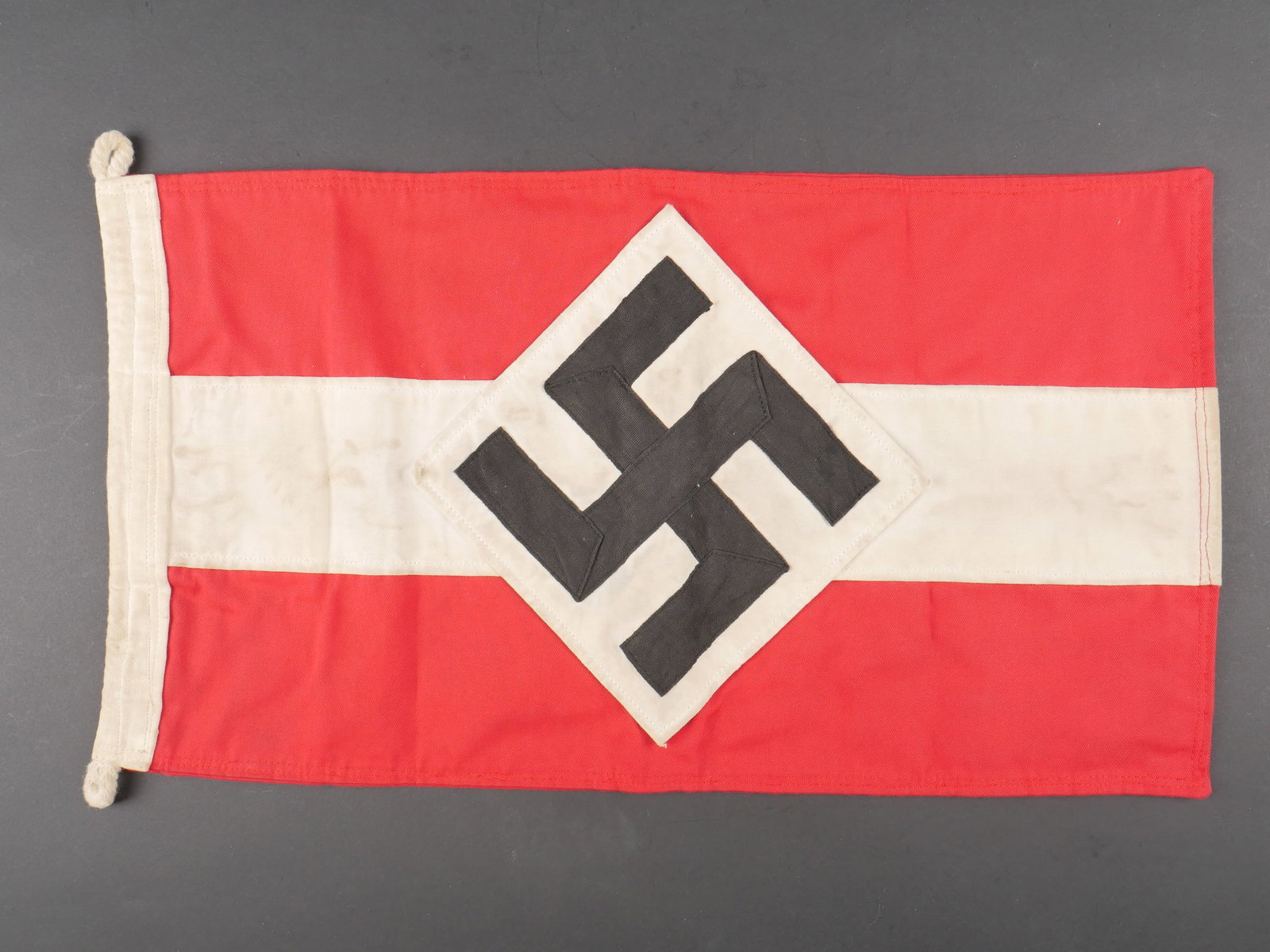 Fanion HJ. Hitlerjugend pennant.: Fanion Hitlerjugend. En epais tissu blanc et rouge. Les cordons de fixation au mat sont presents. Insigne national allemand realise en plusieurs partis et rapporte. Biface. Dimensions 25 x 45 cm. A no