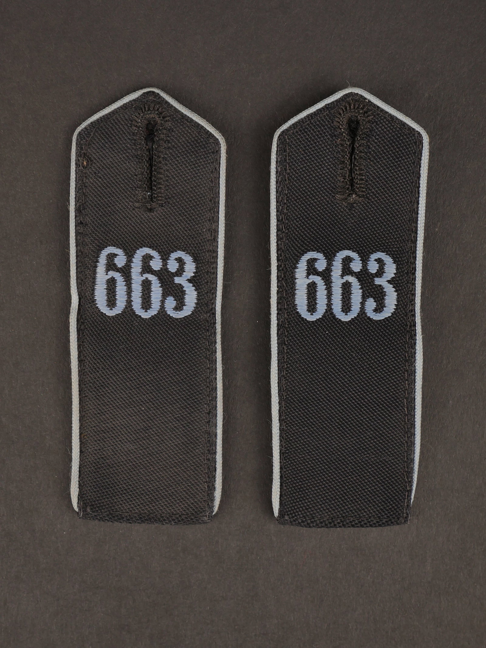 Pattes d epaule HJ. HJ shoulder straps.: Pattes d epaule Hiterjugend. Bann 663 Litzmannstadt. Paire homogene en tissu noir. Lisere bleu. Lettrage 663 brode en fil bleu. Jamais monte. Etiquette RZM numero 263571, code fabricant E St. Une seul