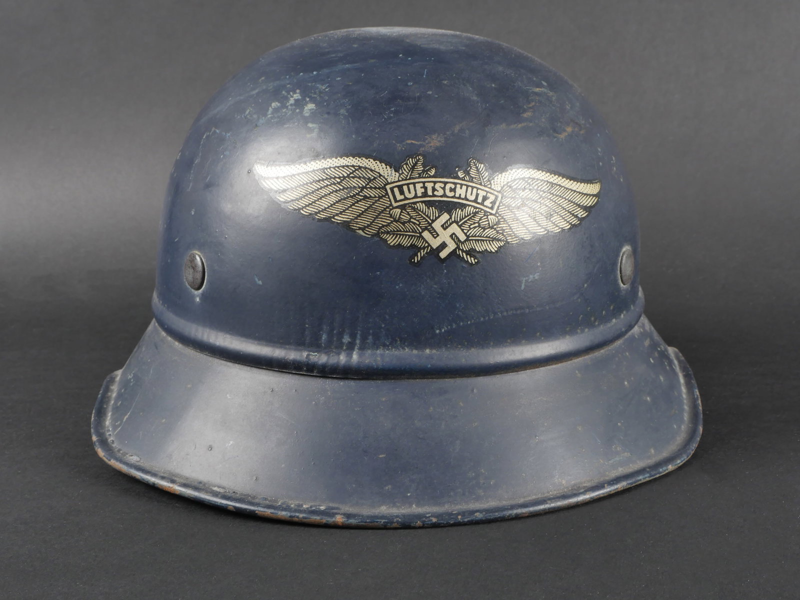 Casque de la Luftschutz. Luftschutz helmet.: Casque de la Luftschutz. Coque de type Gladiateur en metal. Peinture bleu a 80%, quelques marques d oxydation. Insigne de la Luftschutz a 90%. Etiquette dans la nuque indiquant une taille 55. Coiffe e