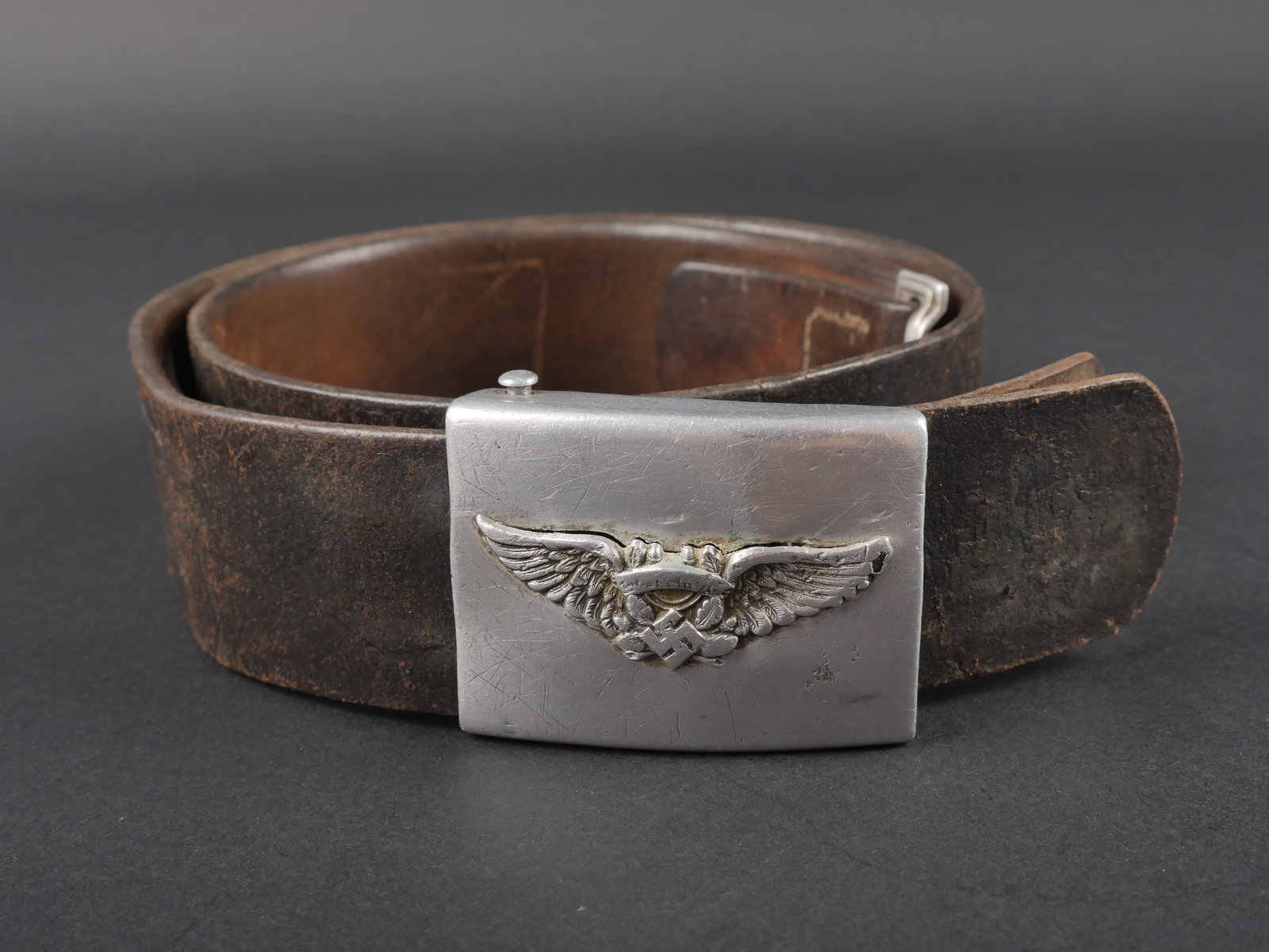 Ceinturon Luftschutz. Luftschutz belt.: Ceinturon Luftschutz. Ceinturon en cuir noir, sans marquages visibles. Taille 90. Bouclerie en metal. Patte de reglage complete. Boucle de ceinturon en metal, insigne de la Luftschutz fortement abime.