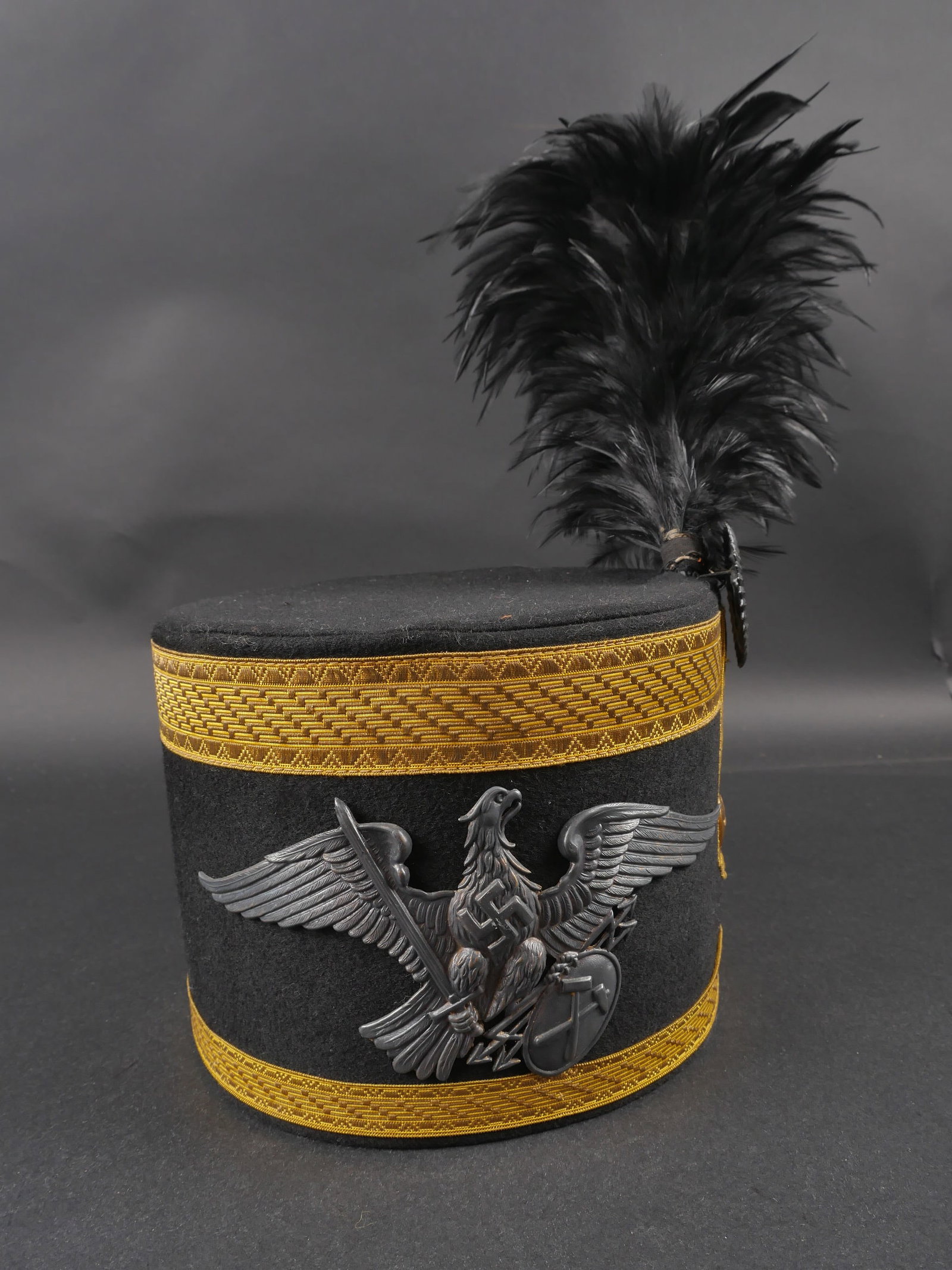 Shako de mineur allemand. German Miner s Shako.: Shako de mineur allemand. En feutrine noire. Double galon or faisant le tour de la coiffure. Plumet en plumes noires present, avec sa cocarde. Bouton estampille de l insigne des mineurs. Insigne metal