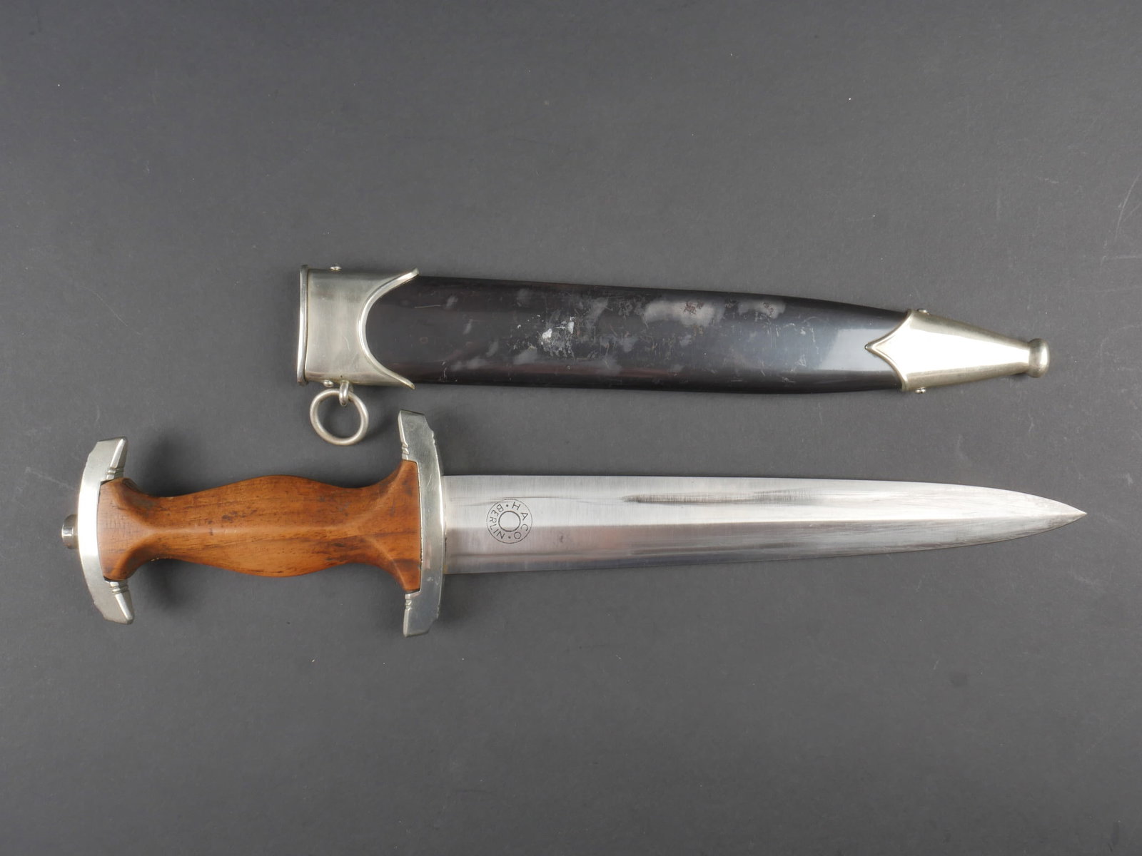 Dague NSKK. German NSKK dagger.: Dague NSKK. Garnitures en metal. Poignee en bois marron. Insigne SA visiblement monte d origine. Aigle allemand egalement monte d origine. Garde marquee B. Lame usee avec traces d oxydation. Devise Al