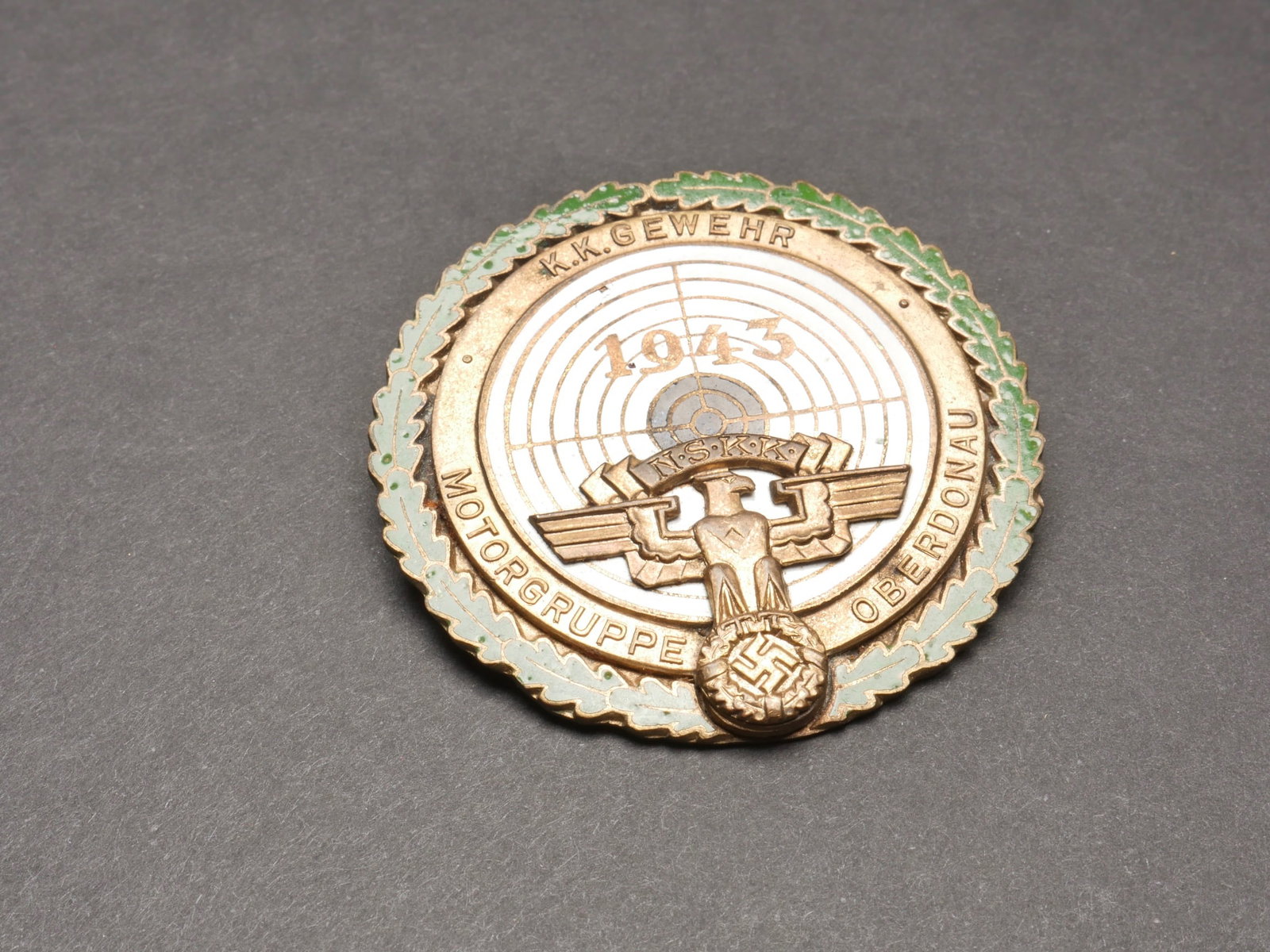 Prix de tir NSKK. NSKK shooting price.: Prix de tir NSKK. Meisterschutze. En metal emaille. Bordure doree a 80%. Bel aigle NSKK en relief. 1943. Pour une competition de KK Gewehr. Motorgruppe Oberdonau. Attache complete, sans marquage fabri