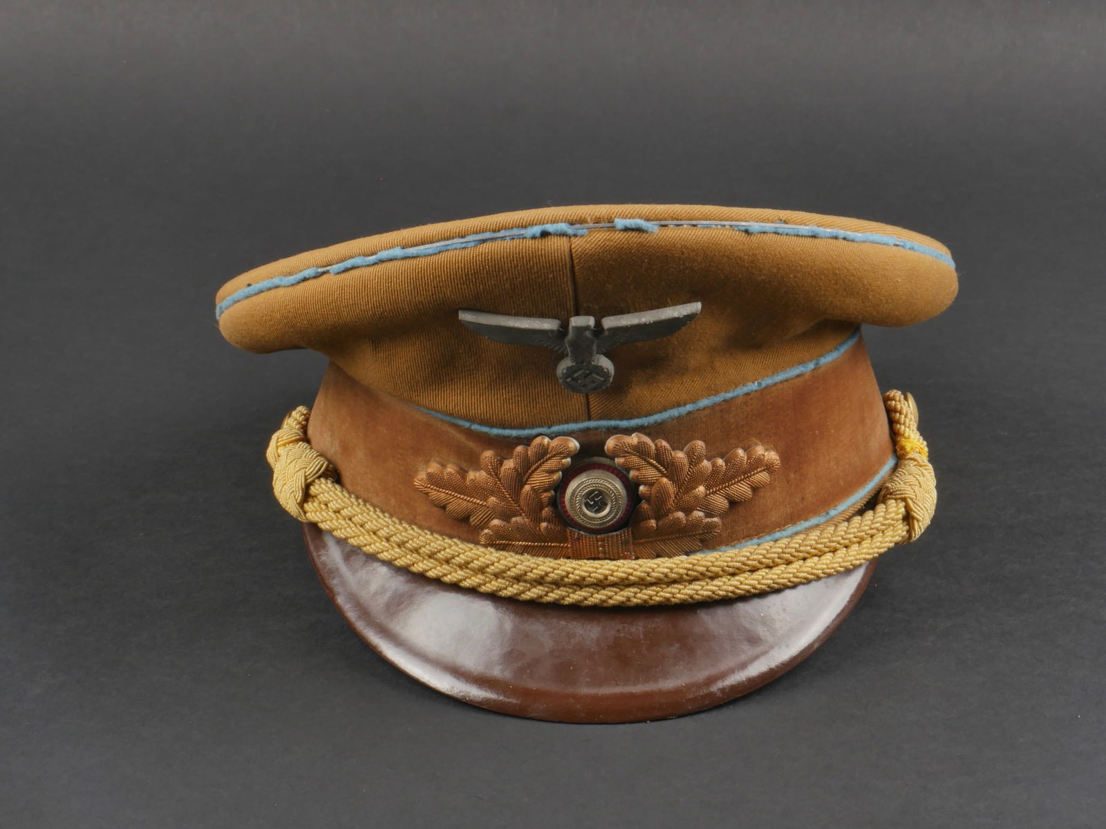 Casquette Politischer Leiter. Politischer Leiter cap.: Casquette Politischer Leiter. En tissu kaki. Triple lisere bleu fortement mites. Bandeau en velours marron. Insignes metalliques. Les insignes n ont pas ete demontes afin de verifier les attaches. Fau