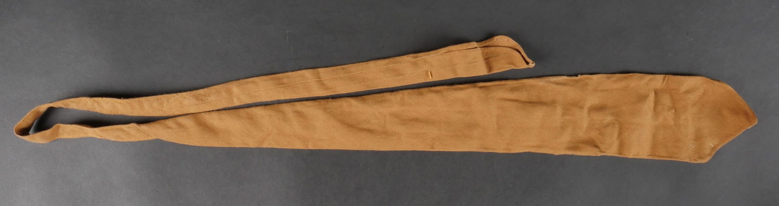 Cravate allemande. German tie.: Cravate allemande. En tissu coton kaki. Etiquette numero 443379, code fabricant B20/85. A noter une certaine usure et patine de la piece, ainsi que quelques taches. Etat II+. German Tie. Made of khaki