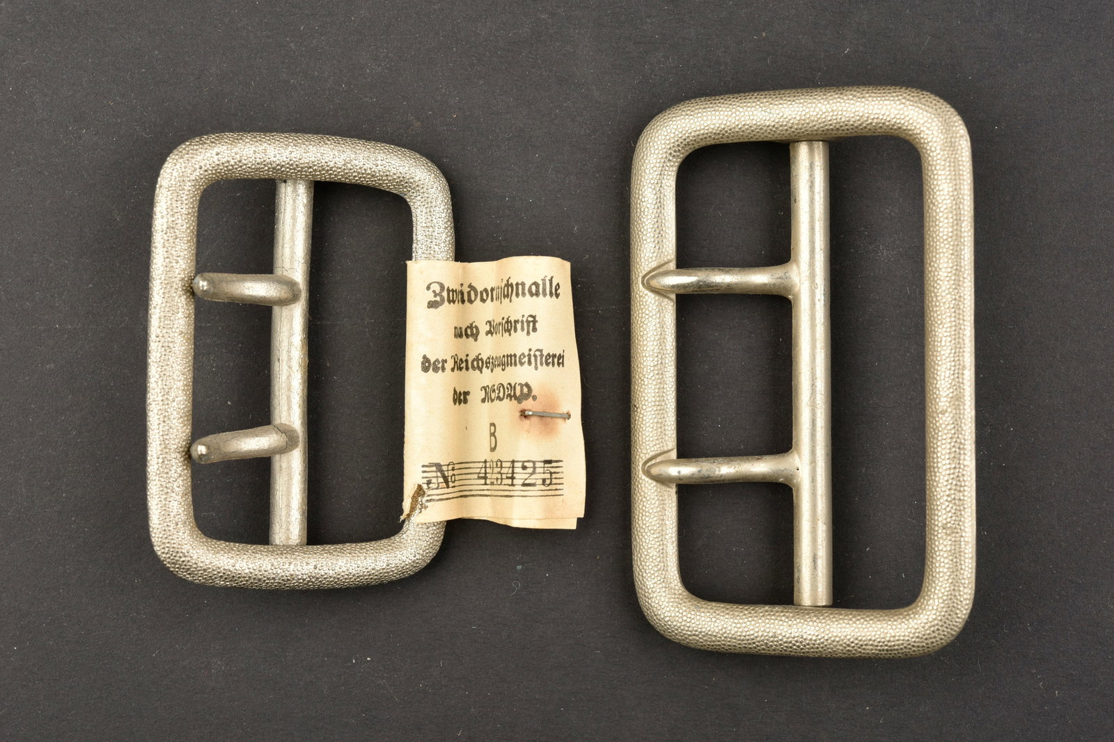 Boucles de ceinturon NSDAP. NSDAP belt buckles.: Boucles de ceinturon NSDAP. Comprenant une boucle de ceinturon en metal grenele, couleur argent, deux ardillons, sans marquages visibles, modeles pour Zellenleiter. Une boucle de ceinturon en metal gr