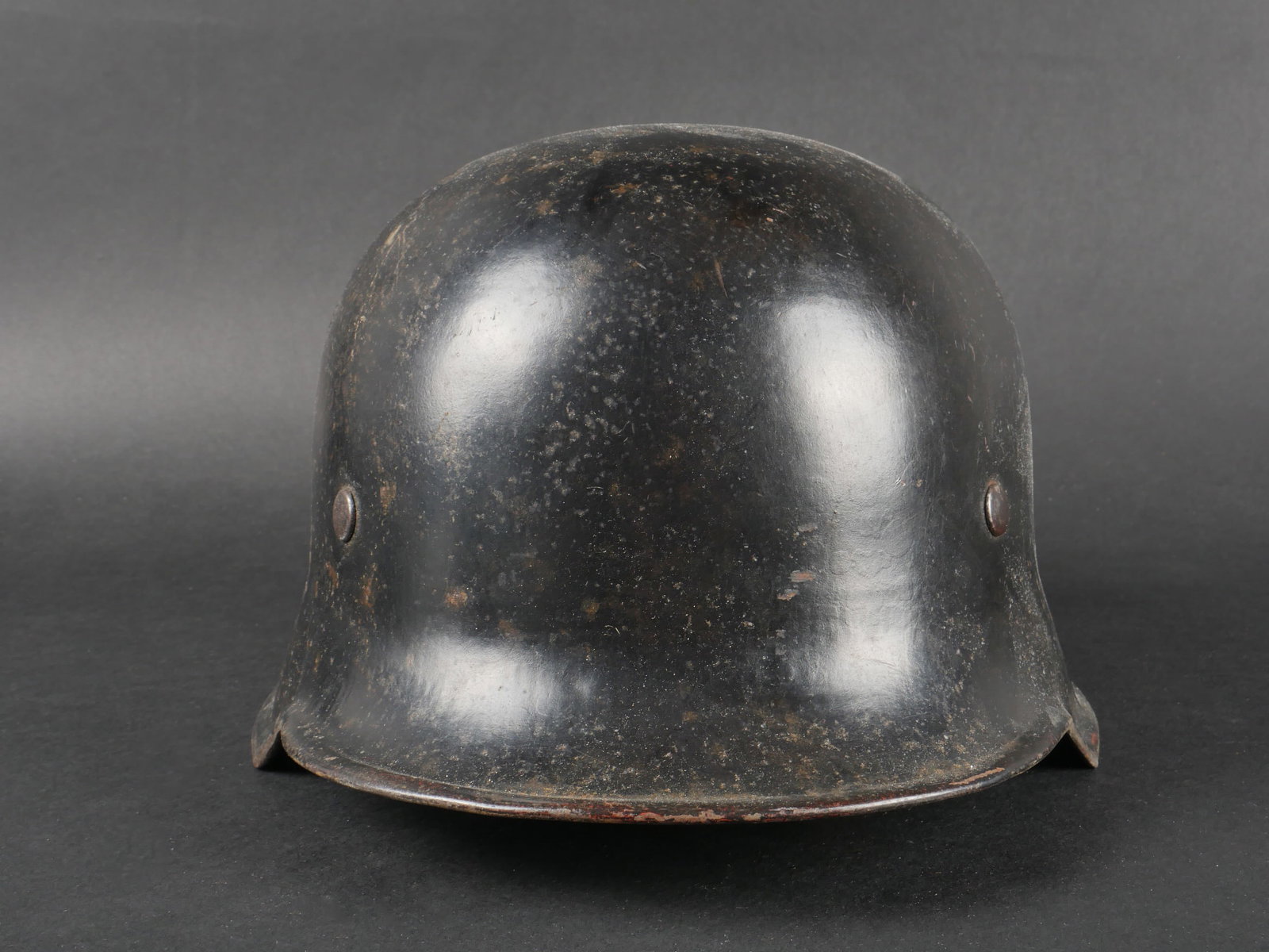 Casque de pompier du Reich.: Casque de pompier du Reich. En metal, couleur noire a 80%. Quelques marques d oxydation. Quatre points d aeration sur les cotes. Insigne de la Police a 80%. Insigne national a 80%. Coiffe en cuir comp