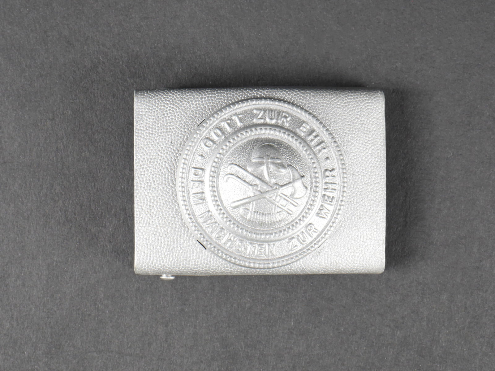 Boucle de ceinturon pompier.: Boucle de ceinturon des pompiers du Reich. En aluminium grenele. Fabrication en deux parties. Boucle a deux ardillons presente et complete. Sans marquages visibles. A noter une certaine usure et patin