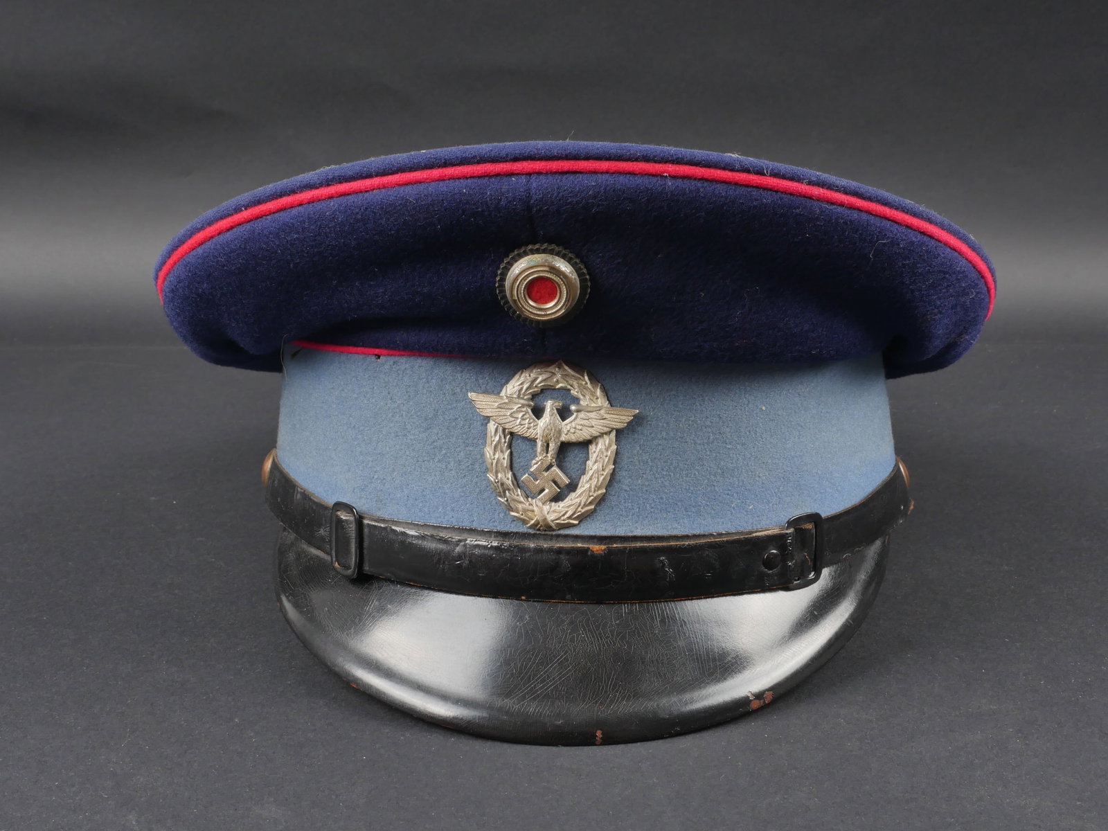 Casquette Feuerschutzpolizei. German Firefighter helmet.: Casquette Feuerschutzpolizei. En drap bleu marine, triple lisere rose. Cocarde metallique. Aigle metallique presentant une certaine usure. Les insignes n ont pas ete demontes afin de verifier les atta