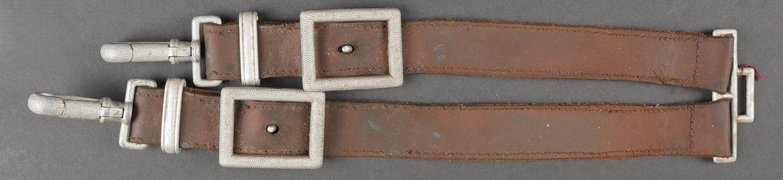 Belieres de dague RAD. Hangars of RAD Dagger.: Belieres de dague RAD. En cuir marron fortement graisse. Bouclerie en metal grenele, couleur argent. Les mousquetons sont fonctionnels. Sans marquages visible. A noter une certaine usure et patine de 