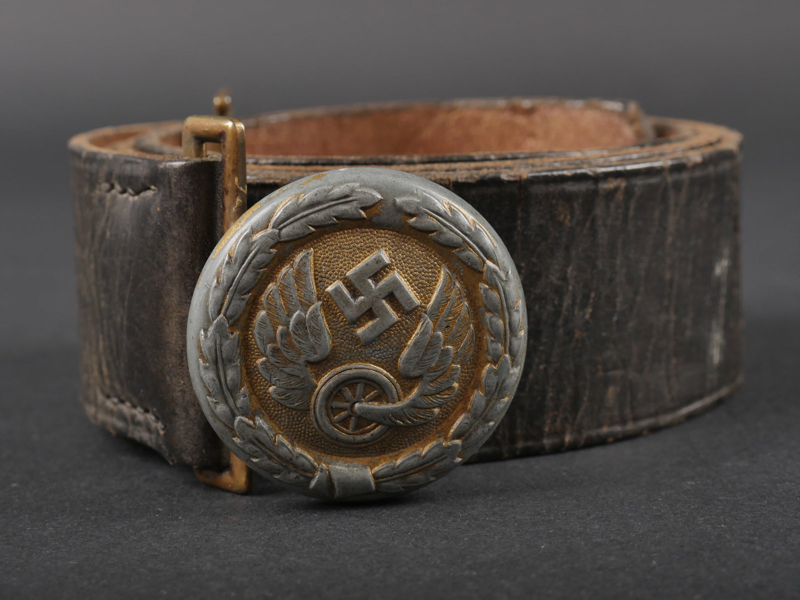 Ceinturon de la Reichsbahn. Reichsbahn belt.: Ceinturon d officier de la Reichsbahn. Ceinturon en cuir noir, presentant quelques craquelures. Patte de reglage complete. Sans marquages visibles. Bouclerie en metal dore. Boucle de ceinturon d offic