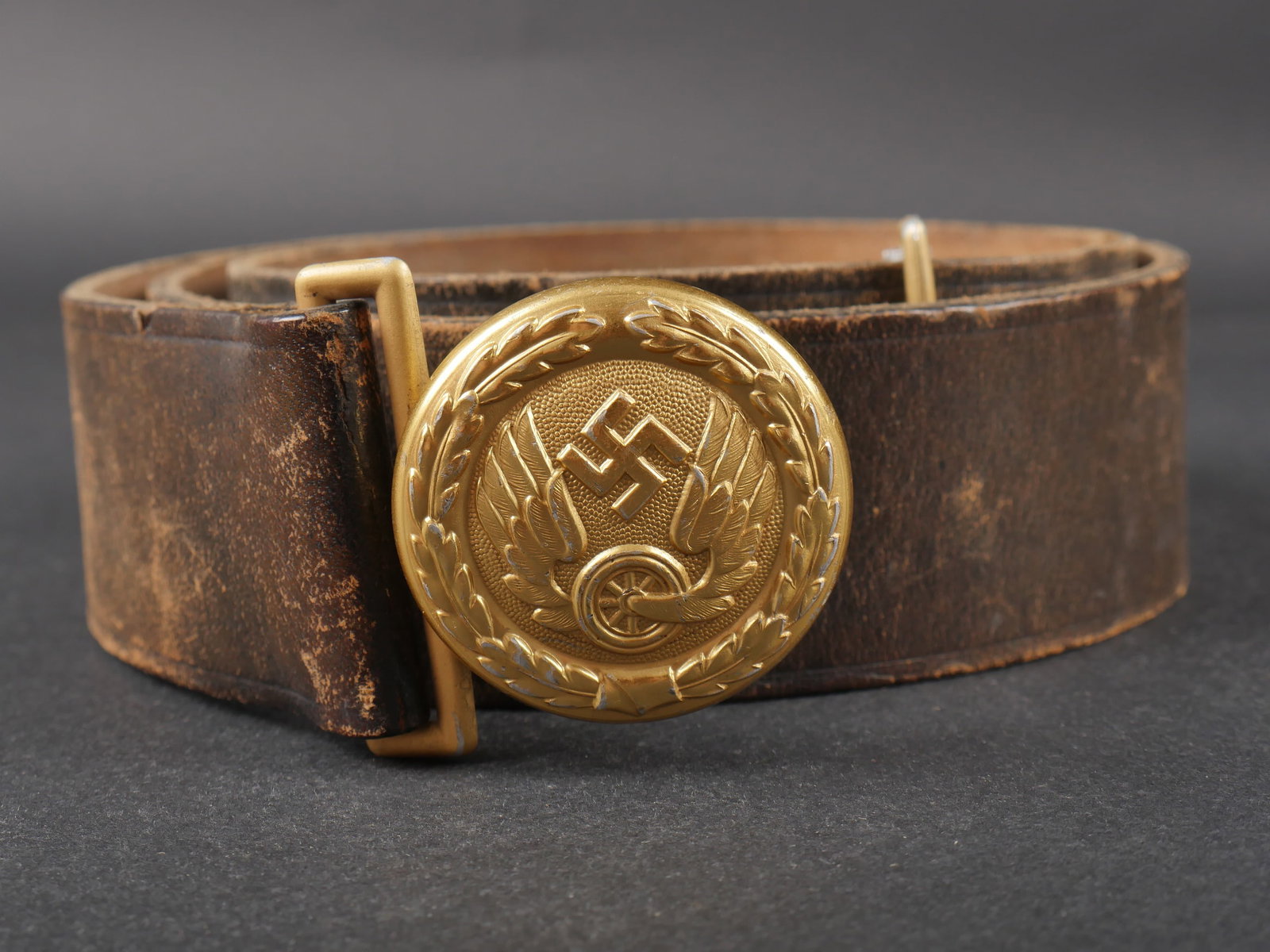 Ceinturon de la Reichsbahn. Reichsbahn belt.: Ceinturon d officier de la Reichsbahn. Ceinturon en cuir noir, presentant quelques craquelures. Nombreux points de reglage. Sans marquages visibles. Bouclerie en metal dore. Boucle de ceinturon d offi