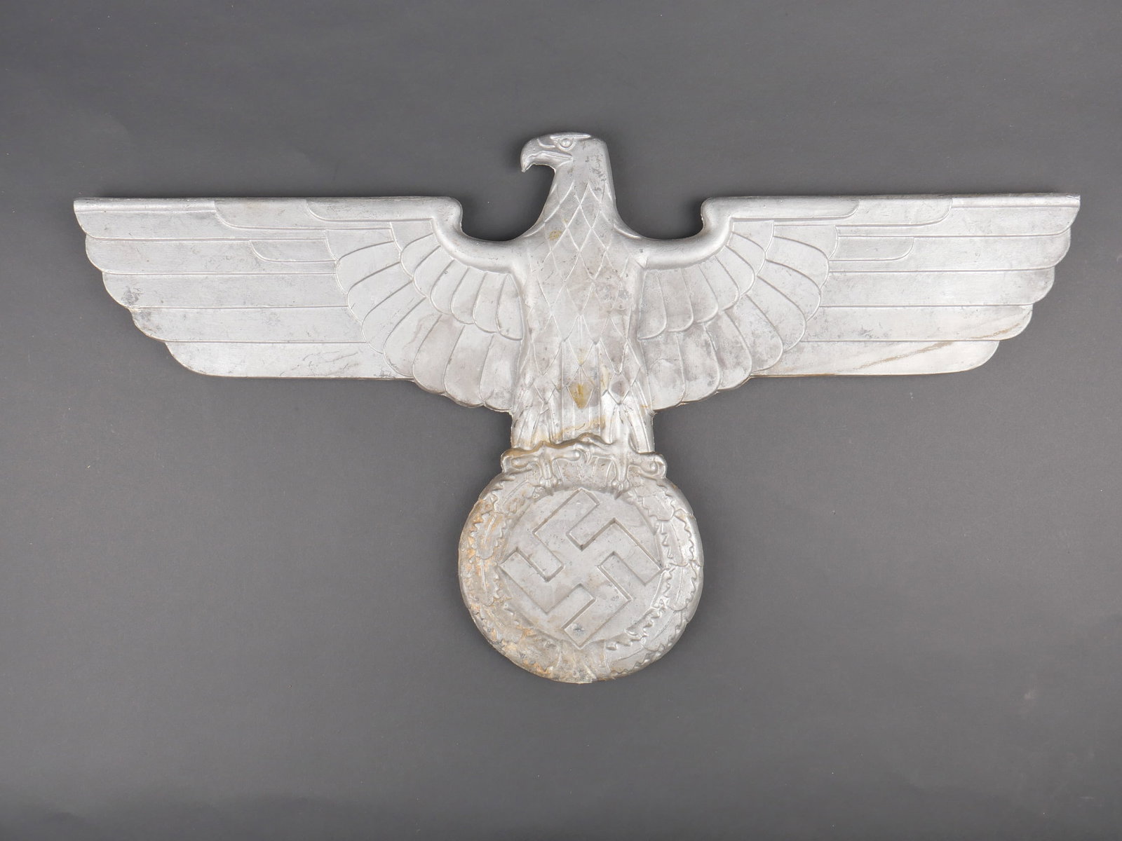 Aigle de wagon. German wagon eagle.: Aigle de wagon allemand. En metal. Couleur argent a 70%. Trois points de fixation. Marqugaes Gal MG St F 13. Dimensions 62 x 34,5 cm. A noter une certaine usure et patine de la piece. Etat II+.