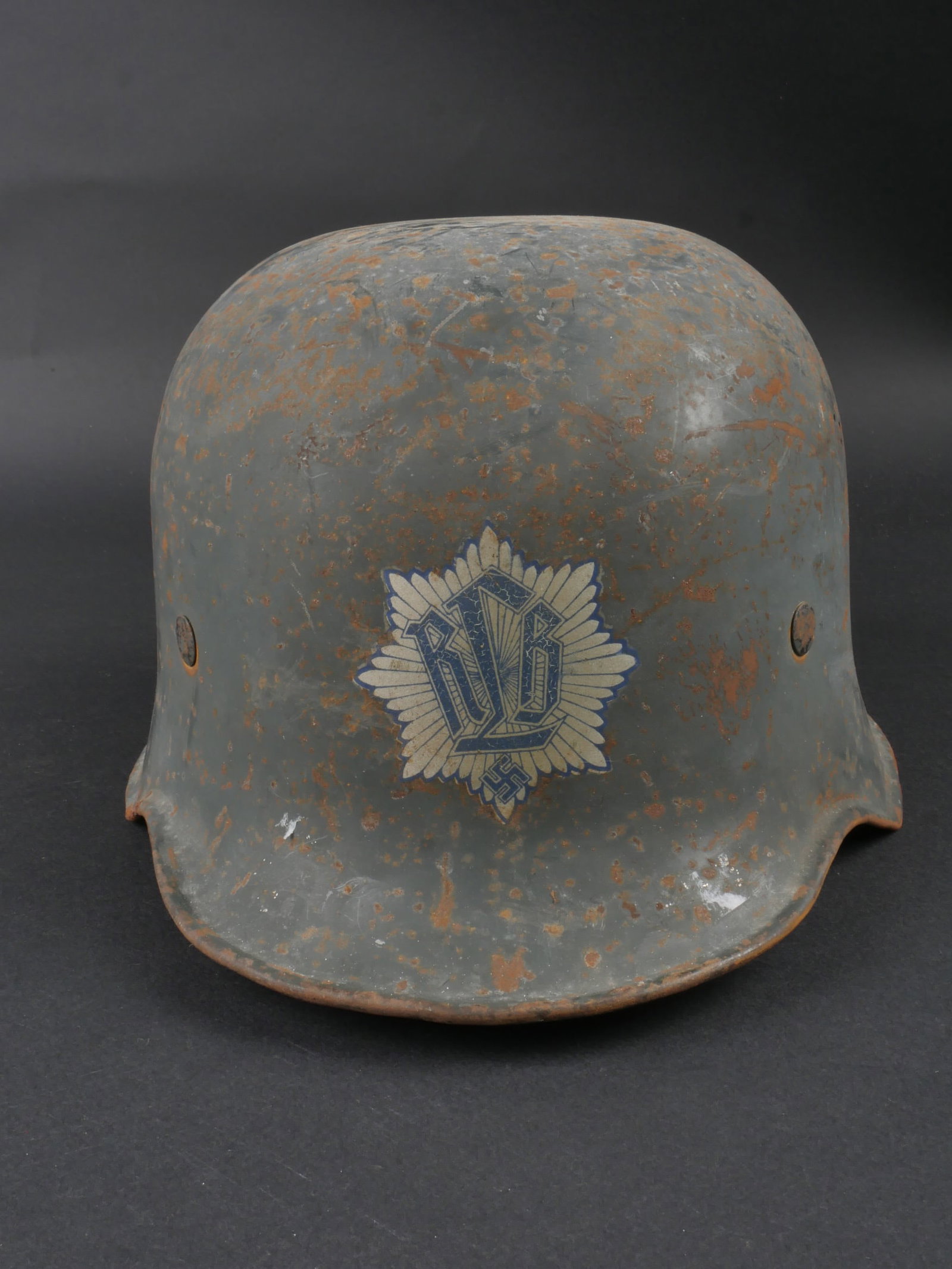 Casque du RLB. RLB helmet.: Casque du RLB. En metal, quatre points d aeration. Insigne RLB a 80%. Peinture gris/bleu a 70%. Coiffe en cuir complete. Cordon de serrage posterieur. Jugulaire en cuir complete. A noter une certaine 