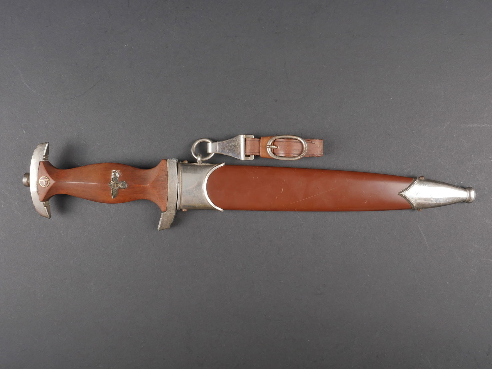 Dague SA. German SA dagger.: Dague de service SA. Garniture en metal nickele. La garde est cassee, incomplete et recollee. Poignee en bois marron. Insigne SA visiblement montes d origine, aigle allemand visiblement recolle. Lame