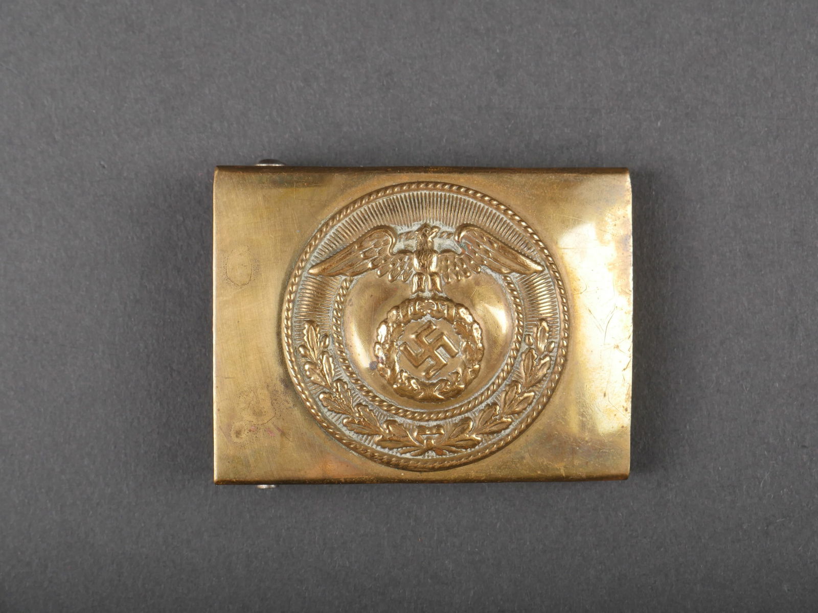 Boucle de ceinturon SA. German SA belt buckle.: Boucle de ceinturon de la SA. En laiton, fabrication en deux parties. Boucle a deux ardillons presente. Sans marquages visibles. A noter une certaine usure et patine de la piece. Etat II+. SA Belt Buc