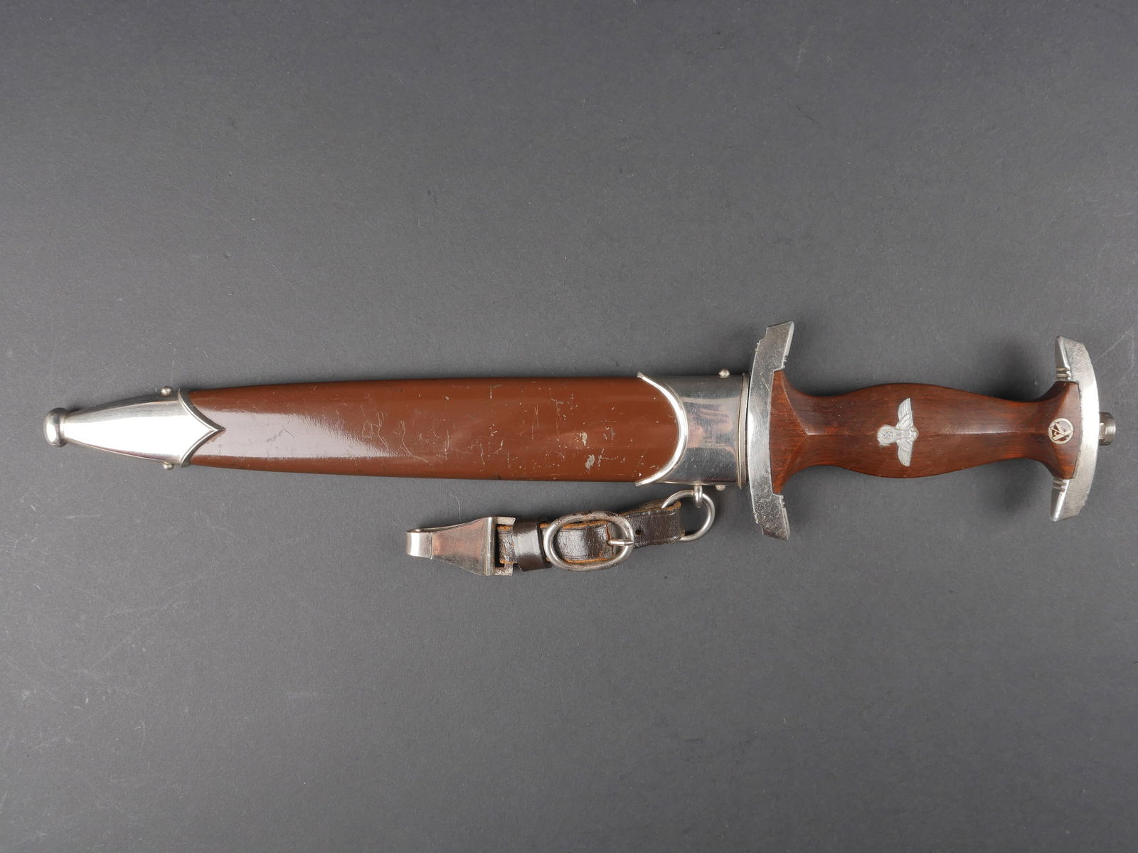 Dague SA. German SA dagger.: Dague de service SA. Garniture en metal nickele. Poignee en bois marron. Insigne SA et aigle allemand visiblement montes d origine. Lame presentant quelques traces d oxydation. Devise Alles Fur Deutsc