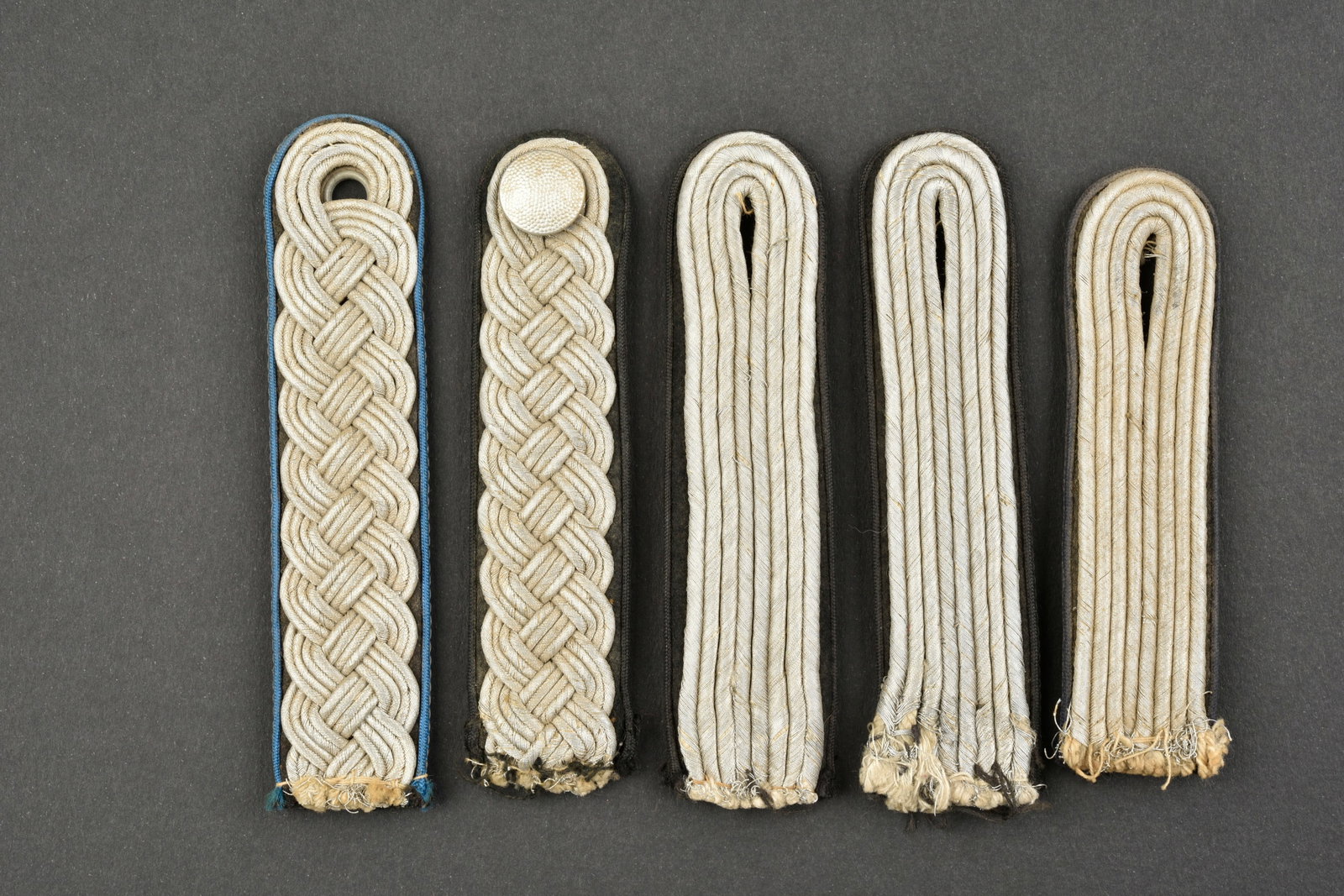 Pattes d epaule NSDAP. NSDAP shouder straps.: Pattes d epaule SA. Comprenant une paire homogene de patte d epaule, tressee argent, support en tissu noir, etiquettes RZM numero 292540 et 292540, code fabricant 21. Une patte d epaule tressee argent