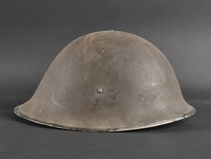 Coque de casque MKIII. MKIII helmet shell: Coque de casque MKIII en metal sans marquages visibles. La coiffe est absente. La jugulaire en toile de type MKIII est presente. La peinture exterieure est conservee a soixantedix pour cent. a noter