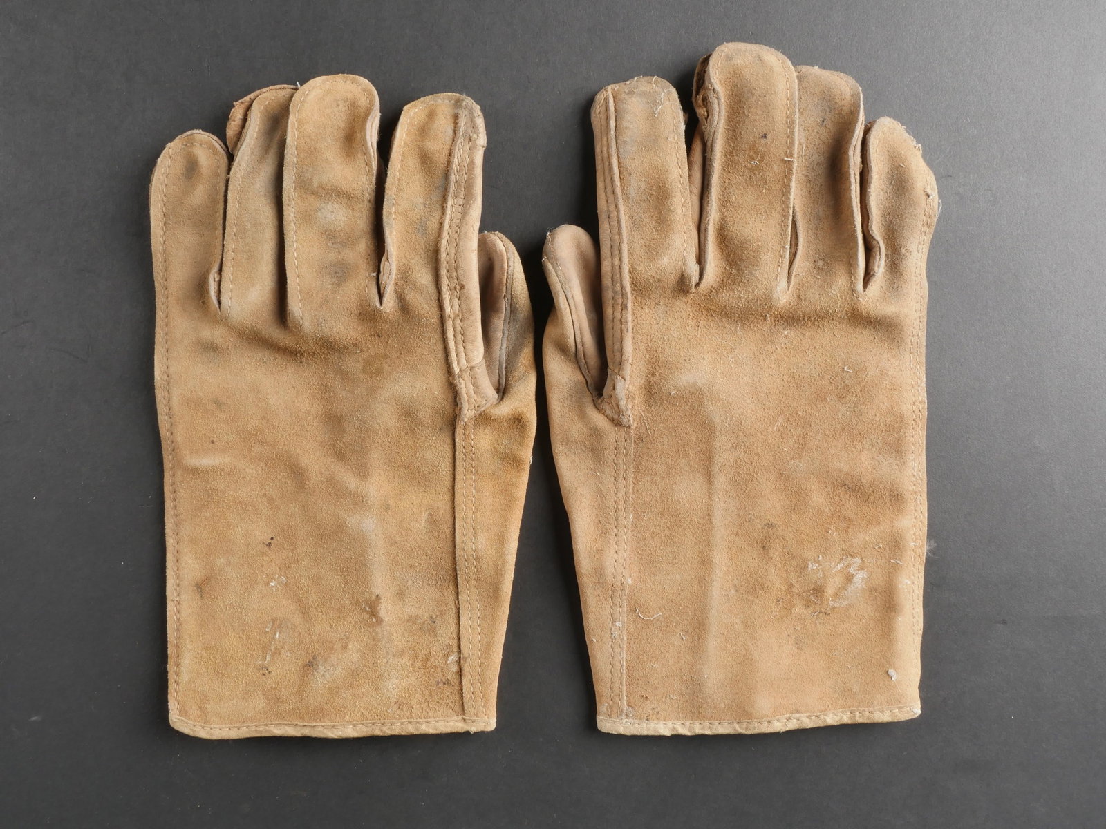 Gants US. US Army Gloves.: Paire de gants americains homogene, confectionnee en cuir. Les marquages sont partiellement illisibles. Il convient de signaler une certaine usure ainsi qu’une patine marquee sur les pieces. Etat II