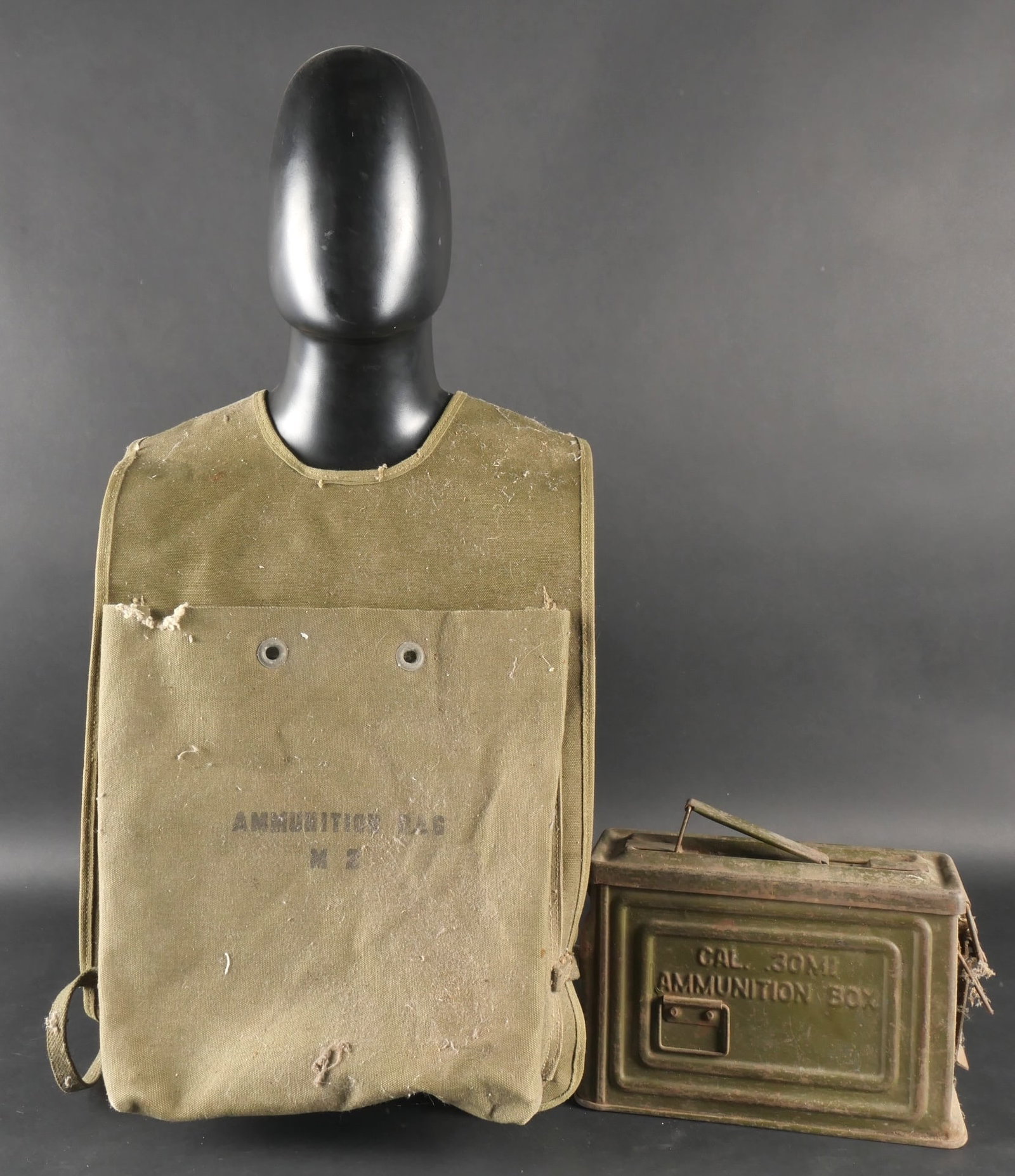 Ammunition Bag M2 US Army.: Sac a munitions M2, confectionne en toile epaisse de teinte OD7, avec des cordons ajoutes posterieurement. Les marquages Ammunitions Bag M2 sont visibles. Toutes les sangles sont presentes. L ensemble