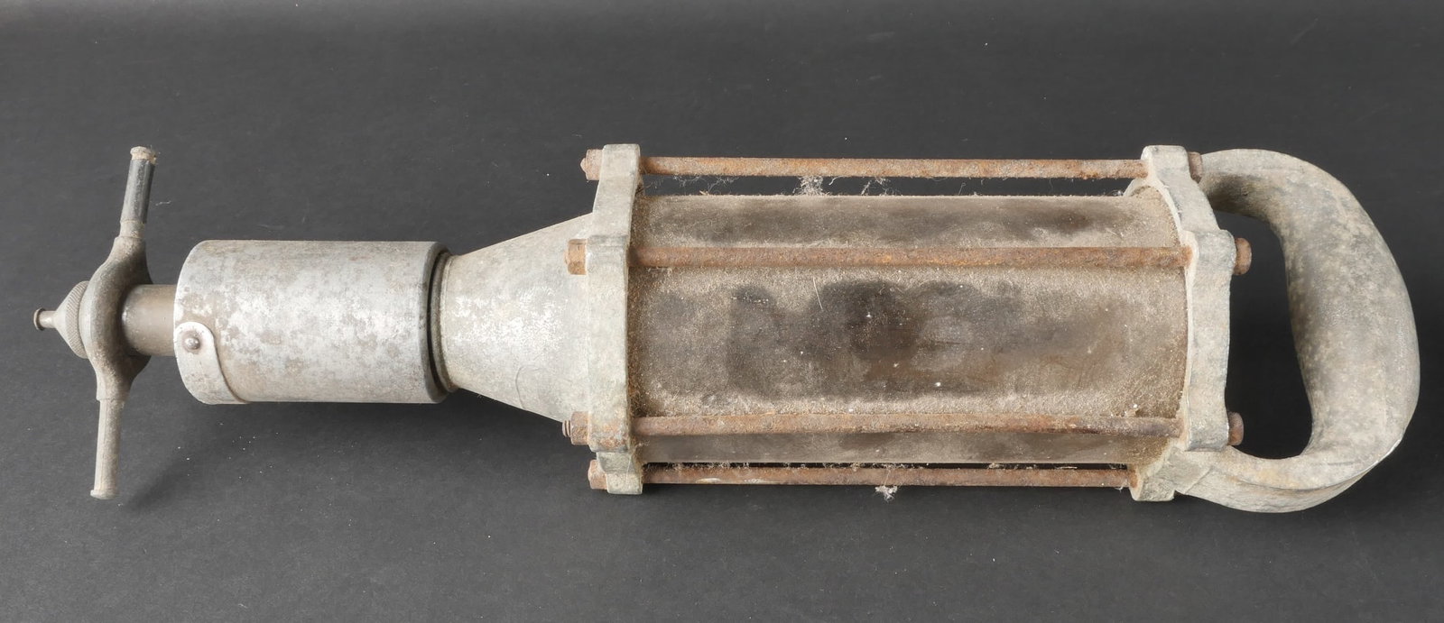 Lampe US. US mechanic’s inspection lamp: Lampe US de modele permettant d’eclairer sous les vehicules, type baladeuse de mecanicien, en metal avec plaquette du fabricant illisible. La poignee de transport est presente. Le verre est en tres 
