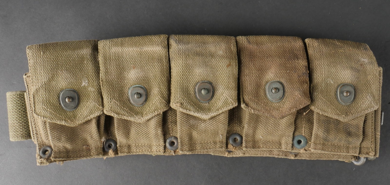 Ceinturon Garand. US Army Garand ammunition belt.: Ceinturon Garand confectionne en toile epaisse de teinte OD7, avec un beau marquage US visible au niveau de la premiere pochette pour munitions. Les boutonpression sont fonctionnels et la bouclerie en