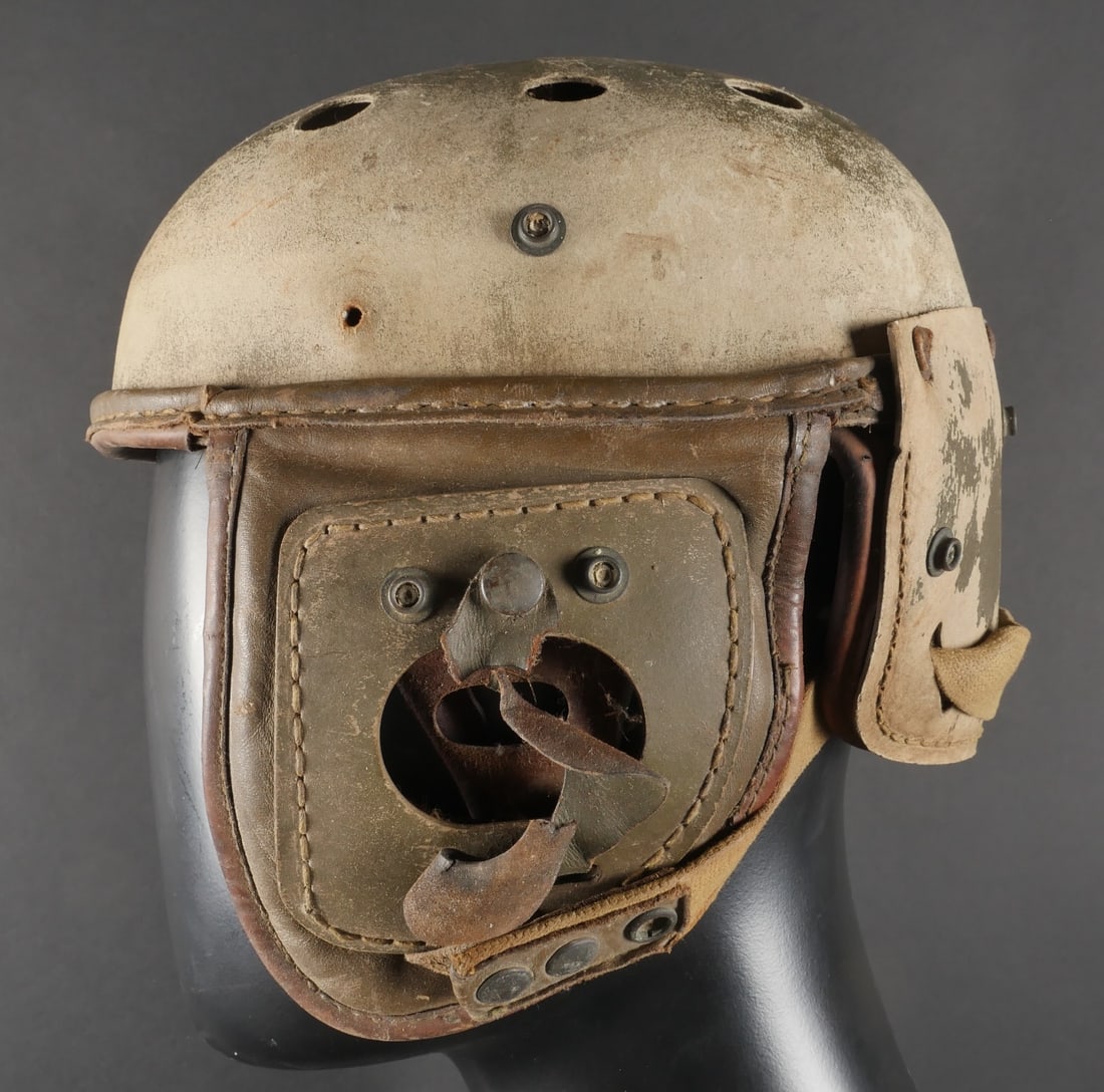 Casque de tankiste US. American tanker helmet: Casque de tankiste americain realise en fibre, dont la teinte kaki d’origine a totalement disparu, laissant apparaitre la couleur naturelle du materiau. Les elastiques situes a l’arriere sont comp