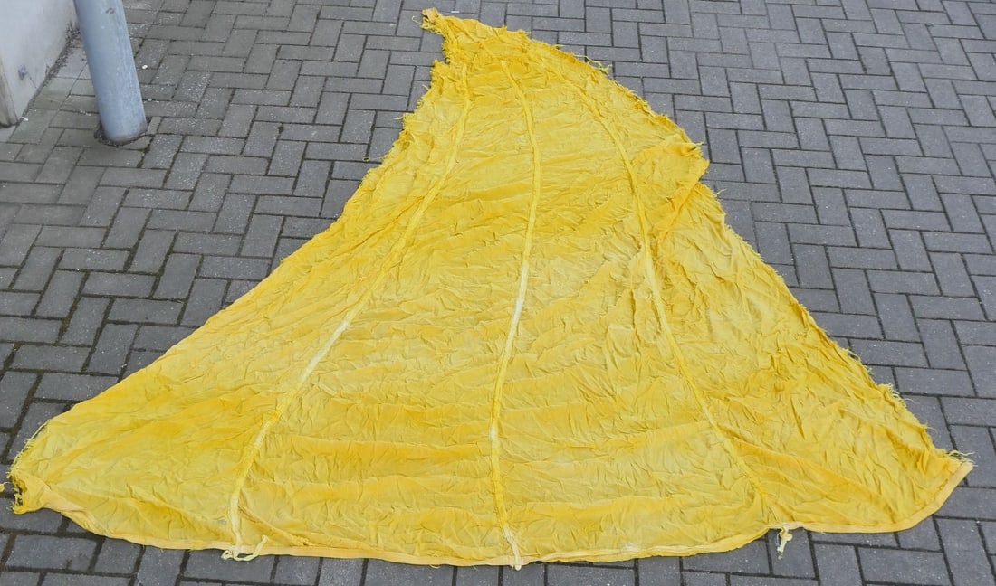Morceau de voilure de parachute US. US parachute canopy fragment: Morceau de voilure US provenant d un parachute de couleur jaune, les suspentes etant manquantes. Aucun marquage visible. La couleur jaune indique qu il s agissait d un largage de materiels medicaux. C