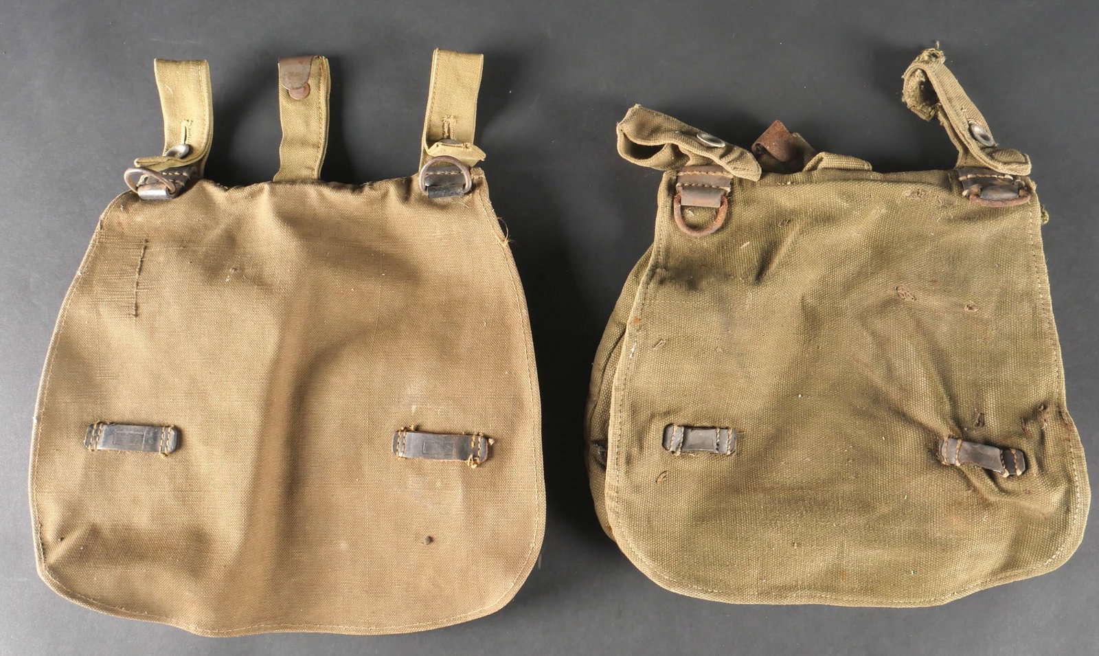 Sacs a pain allemand. German bread bag.: Ensemble de sacs a pain allemands comprenant un premier modele confectionne en toile epaisse de teinte Feldgrau avec renforts en cuir noir. La sangle de transport est absente et une patte arriere est 