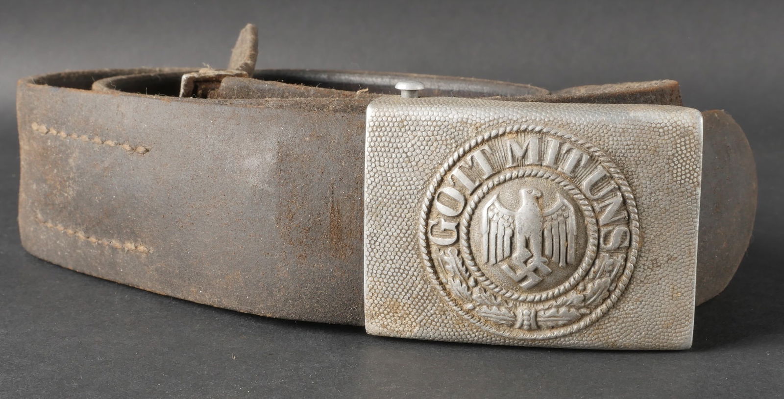 Ceinturon de la Heer. Heer belt.: Ceinturon de la Heer en cuir tres sec, avec une couture defaite. La taille indiquee est 100, bien que les marquages soient illisibles. La patte de reglage est complete. La boucle de ceinturon, en alum