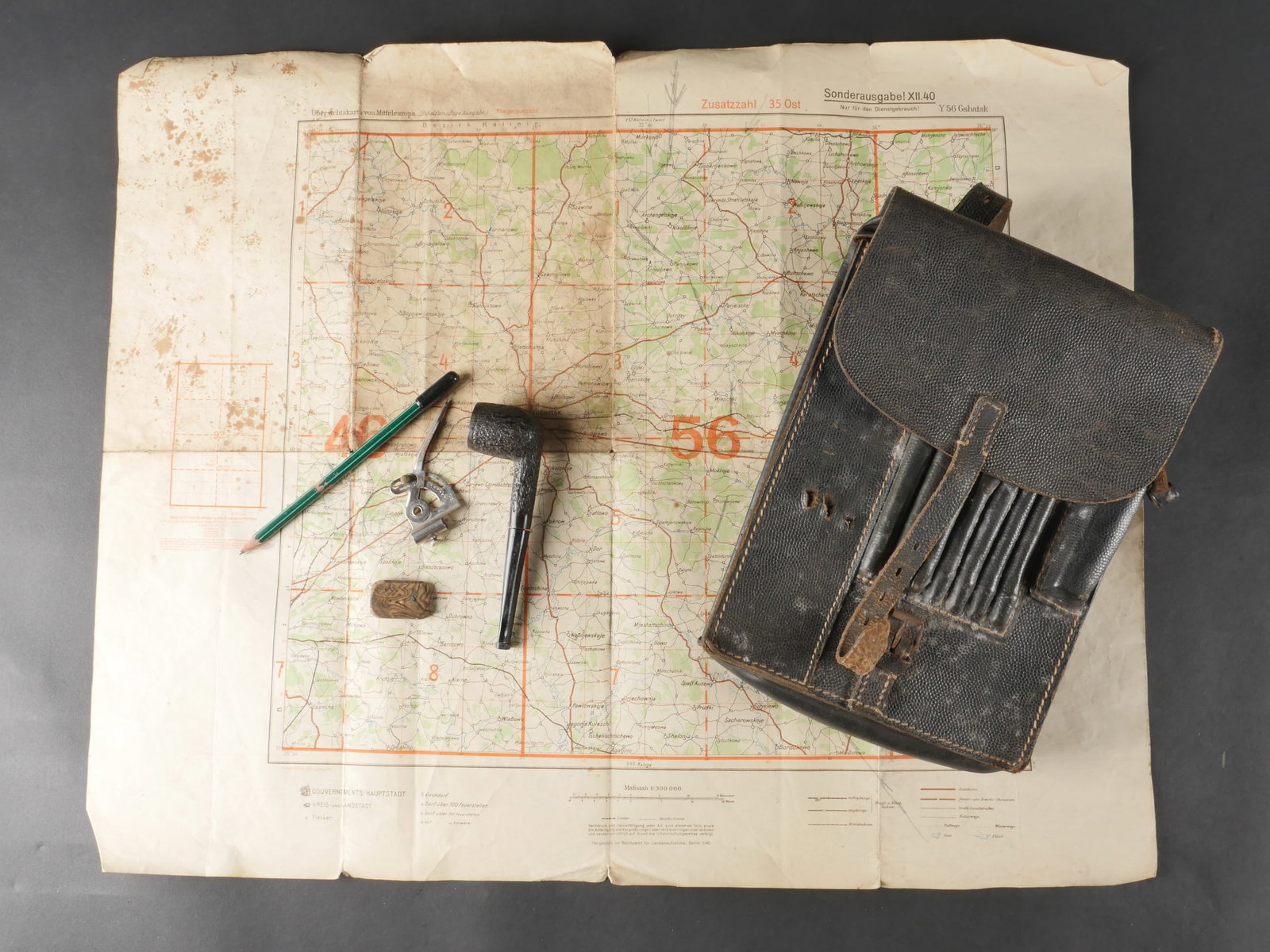 Porte carte allemand. German map case: Portecarte allemand en cuir grenele noir, avec sangle de fermeture complete. Les parties metalliques presentent une oxydation visible. Les passants au dos sont fonctionnels. Aucun marquage du fabrican