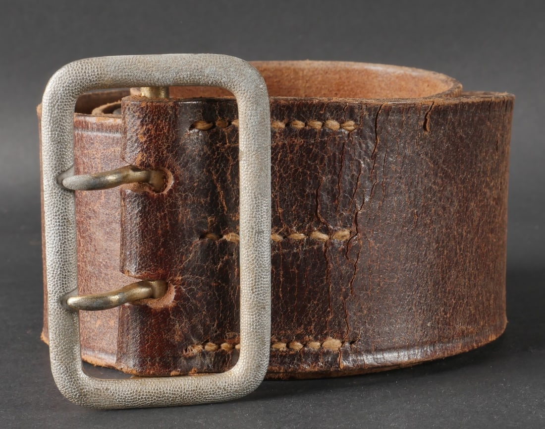Ceinturon d officier allemand. German officer belt.: Ceinturon d officier allemand en cuir marron, equipe d une boucle a deux ardillons en metal grenele argent. Aucun marquage visible n’est present. Il convient de signaler une certaine usure ainsi qu�