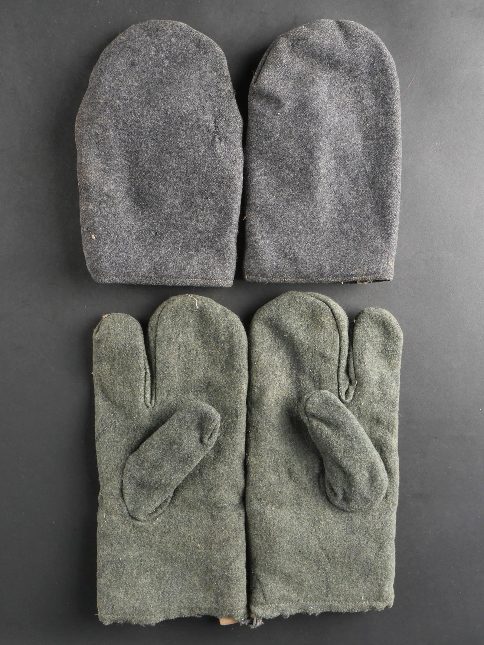 Gants allemand. German military gloves.: Ensemble de gants allemands comprenant une paire homogene de moufles en drap gris/bleu, avec un interieur double en tissu gris, sans marquages visibles. Une seconde paire homogene de moufles, avec ind