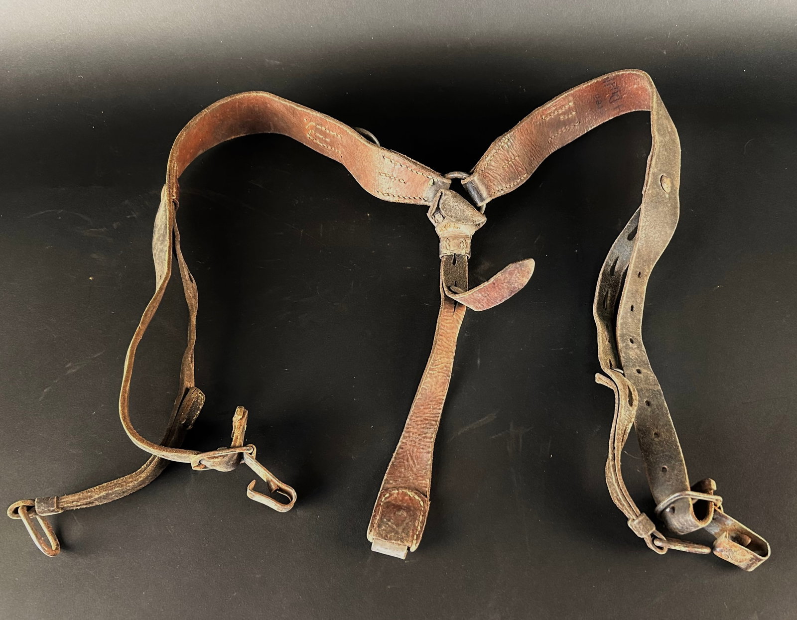 Brelage allemand. German Y strap.: Brelage allemand confectionne en cuir bicolore, demeurant relativement souple malgre son anciennete. Les elements metalliques presentent une oxydation partielle. Les marquages du fabricant sont devenu