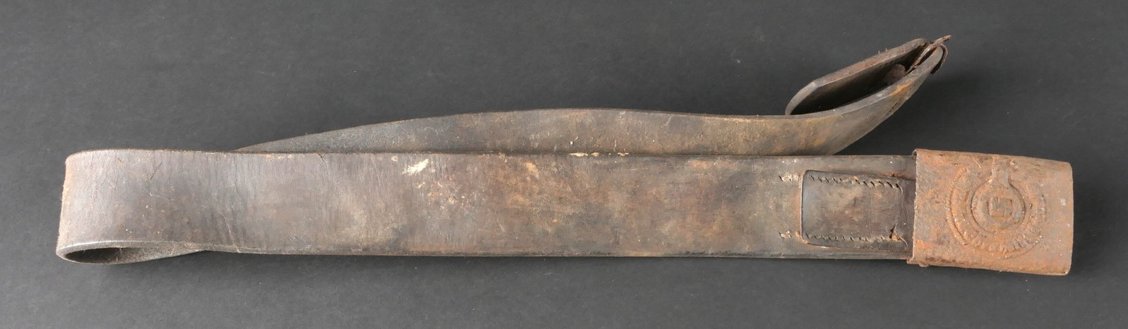 Relique de ceinturon SS. WaffenSS belt relic: Relique de ceinturon appartenant a un soldat de la WaffenSS, confectionne en cuir desormais tres sec et presque rigide. Certaines coutures sont partiellement defaites. Les elements metalliques present